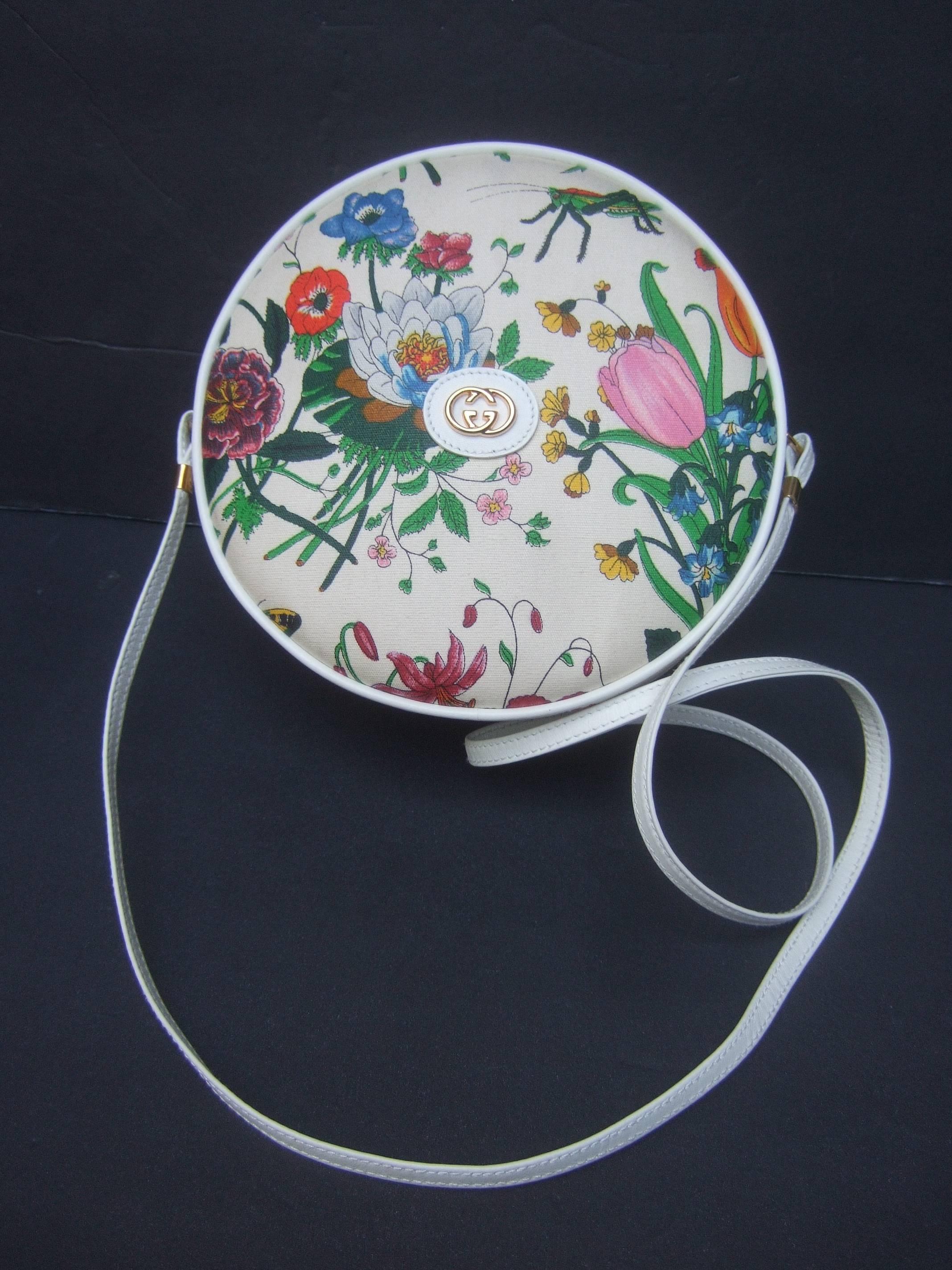 Gucci Rare flora canteen shoulder bag c 1970s
The stylish Italian handbag is designed
with a field of flower blooms that burst
against the white coated canvas covering

Concealed within the garden of flowers 
are a few grasshoppers, beetles