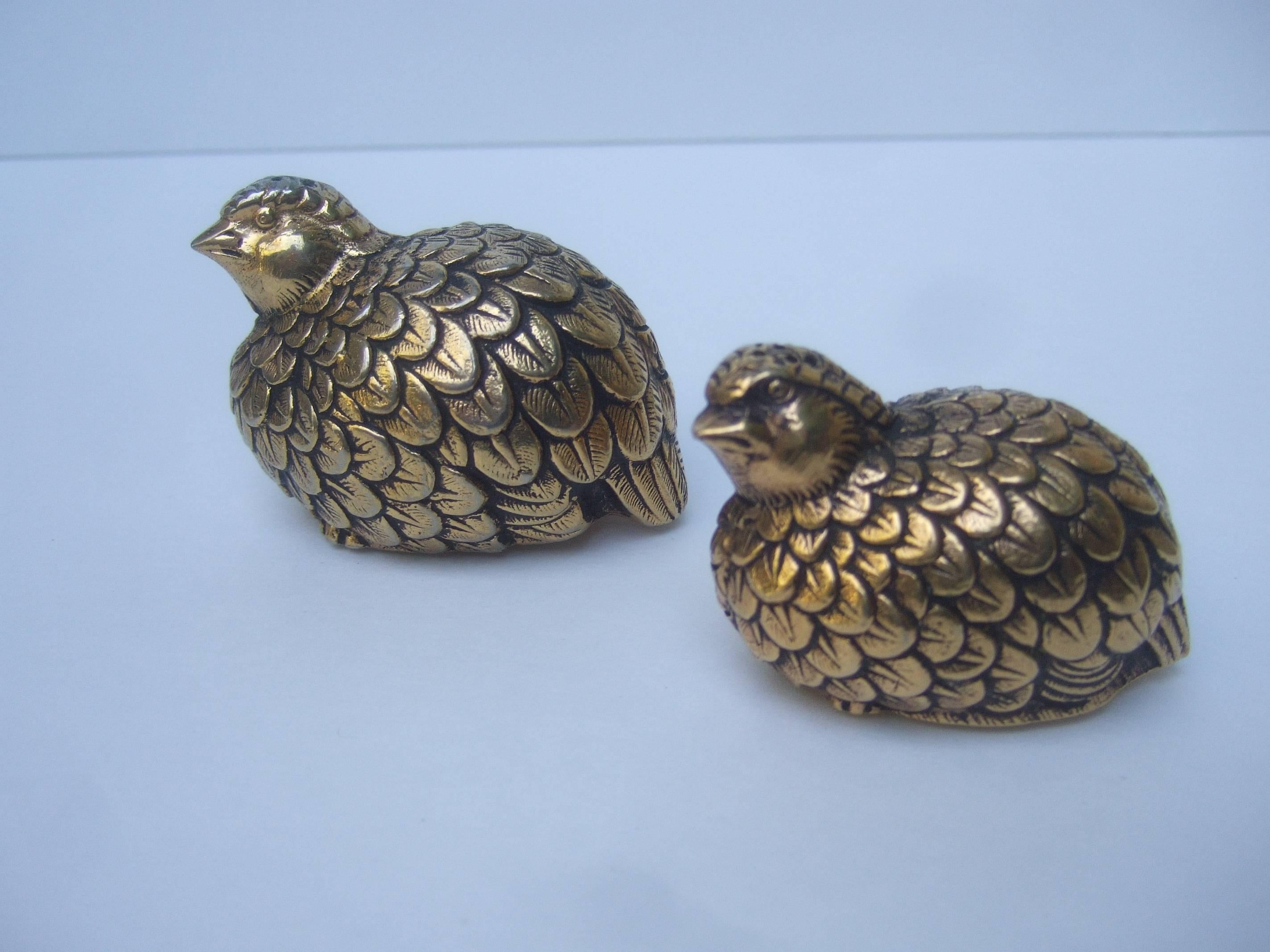Gucci Italy Elegant pair of quail bird salt and pepper shakers
The stylized gilt metal birds are designed with textured detail 
that emulates feathers

The pair of quails are perched together in graduated sizes
The unique pair of Gucci quails
