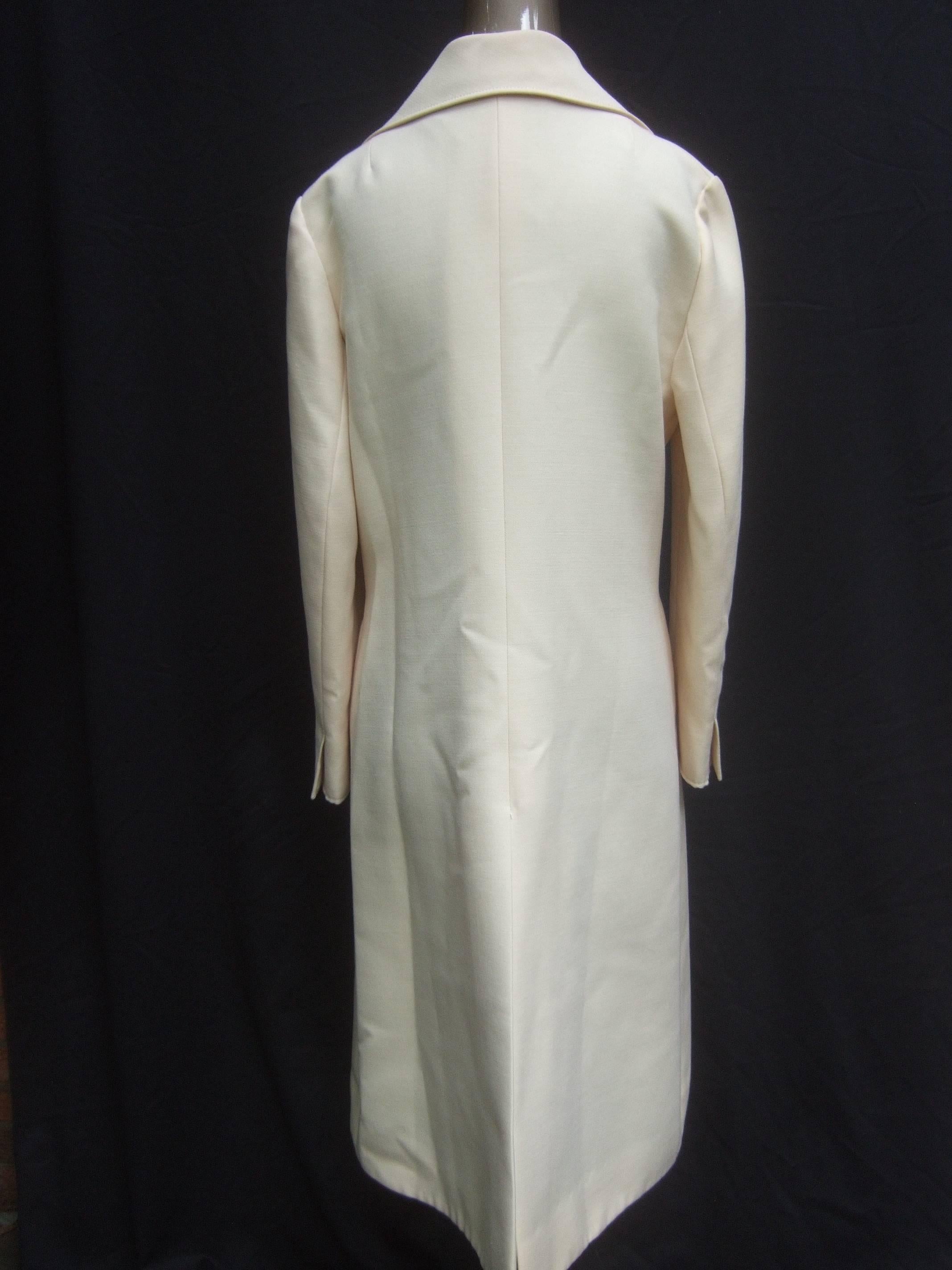 Beautifully tailored 1960's creme wool car coat by Pierre Cardin. Straight cut. Perfect for day into evening. Fully lined. Shiny black enamel buttons. Excellent Condition. Labelled: Creation Pierre Cardin Paris. Measurements:  Length 40.5" 