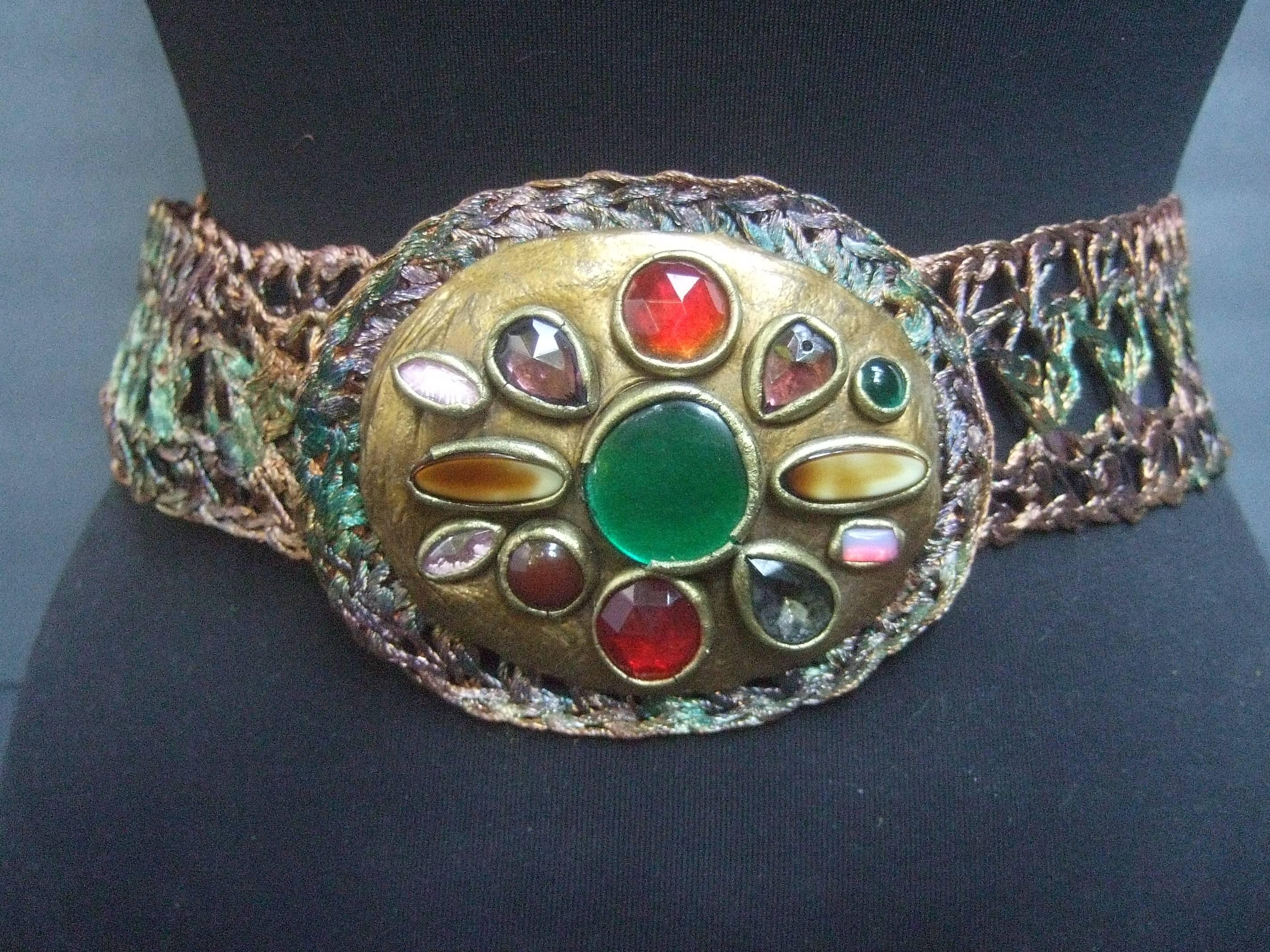 Artisan glass stone buckle woven metal belt c 1980s
The unique handmade artisan belt is designed 
with a large oval shaped buckle embellished 
with a collection of glittering glass stones

The glass stones range from smooth,