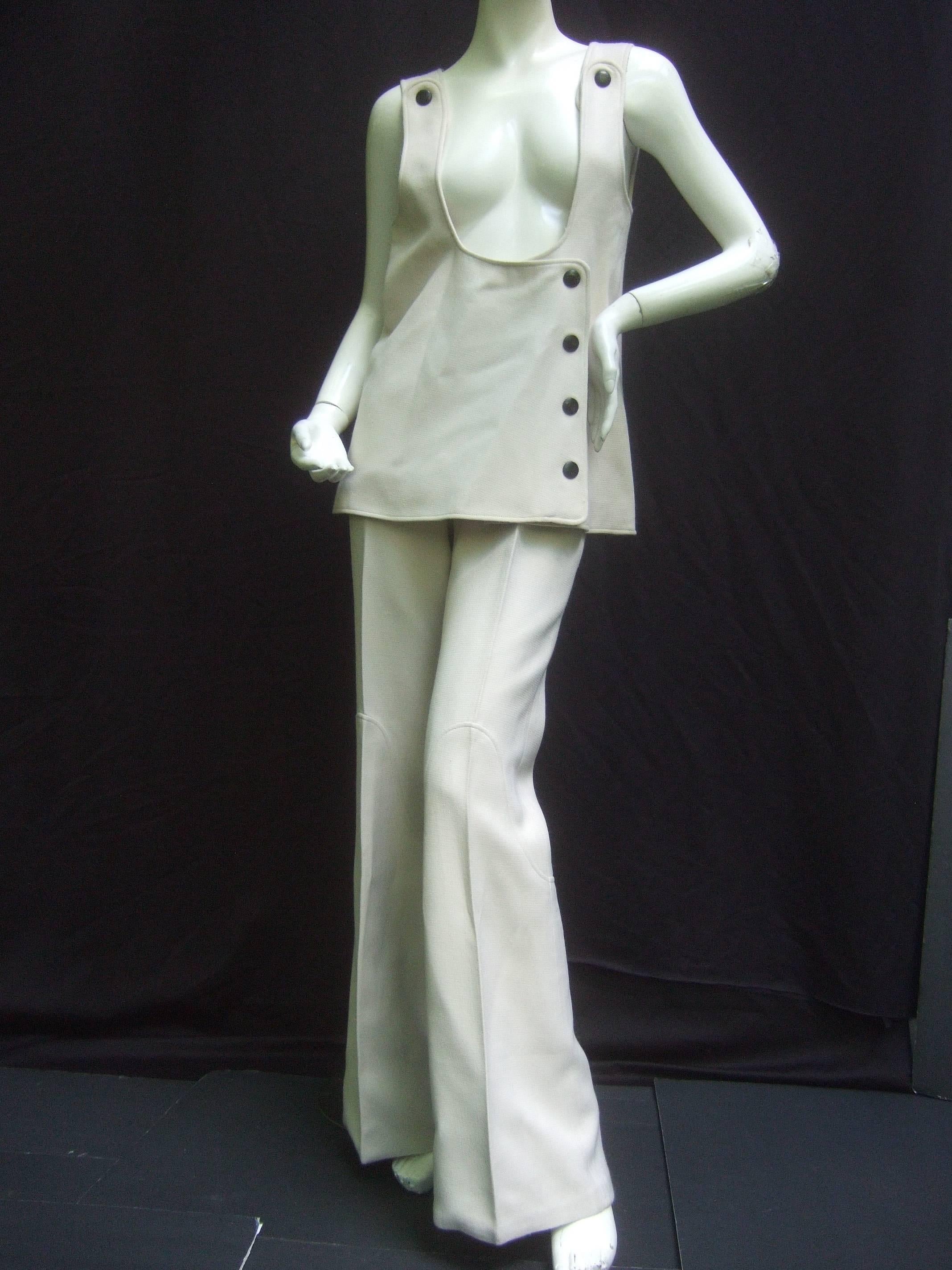This is a museum piece!  Superb space-age tailoring on this 1960's Courreges
couture trouser and tunic suit of heavy ivory wool. Fabulous cut-outs. Big black enamel snap closures.  Great graphic detail on the trousers.  Such clean modernist lines.