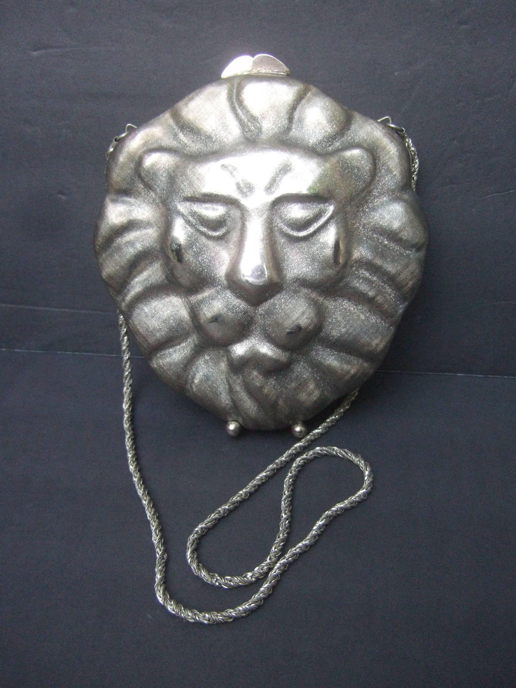 Neiman Marcus Silver metal lion evening bag c 1970s 
The opulent metal purse is designed with a majestic
lion's face on both exterior covers

The lion's face and mane are distinguished with a 
combination of shiny silver tone metal