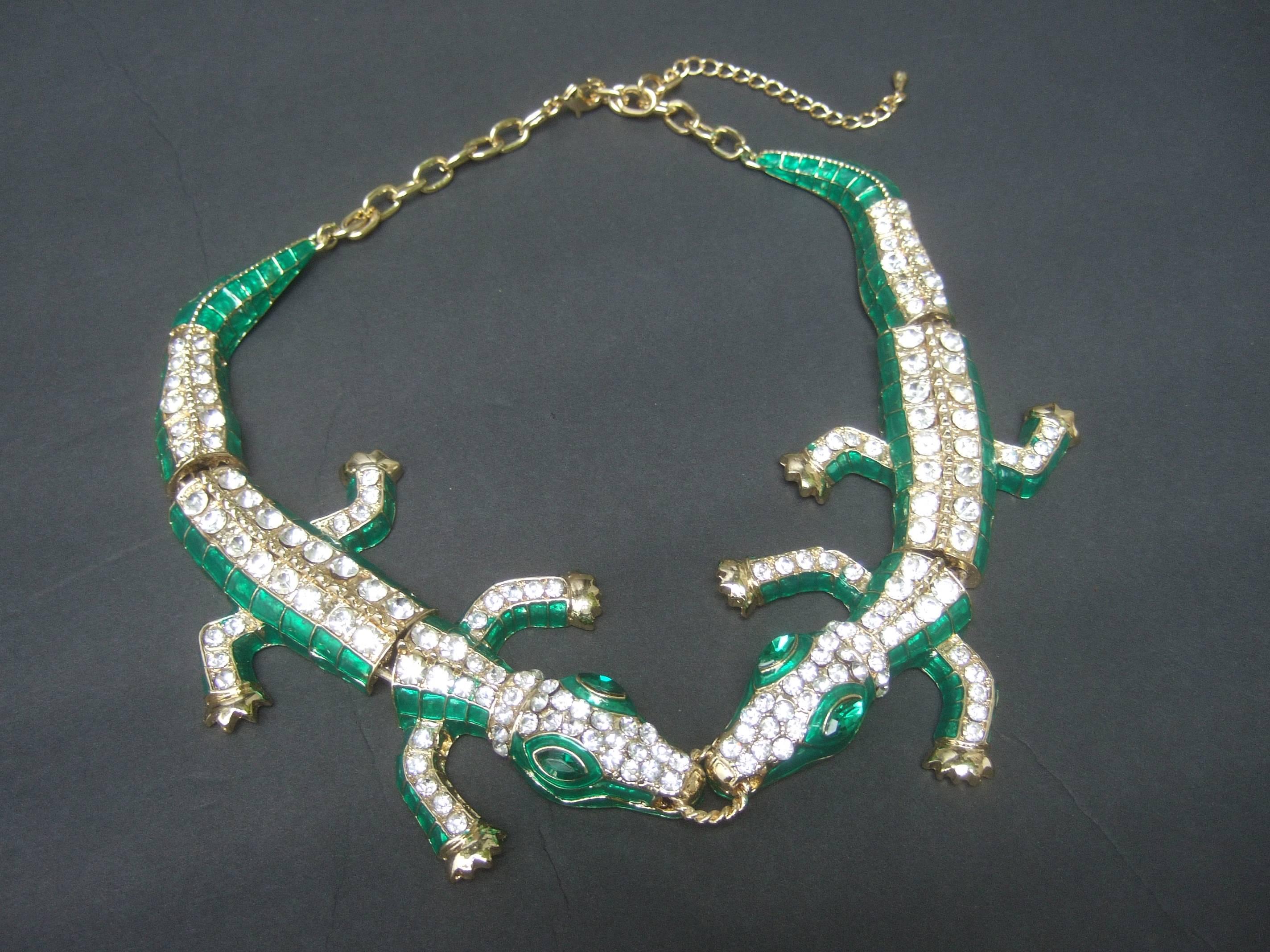 Exotic green crystal articulated enamel alligator necklace
The unique choker style necklace is designed with a 
pair of jewel encrusted alligators; hinged together 
in the center with a gilt metal ring cinched in their mouths

The alligators