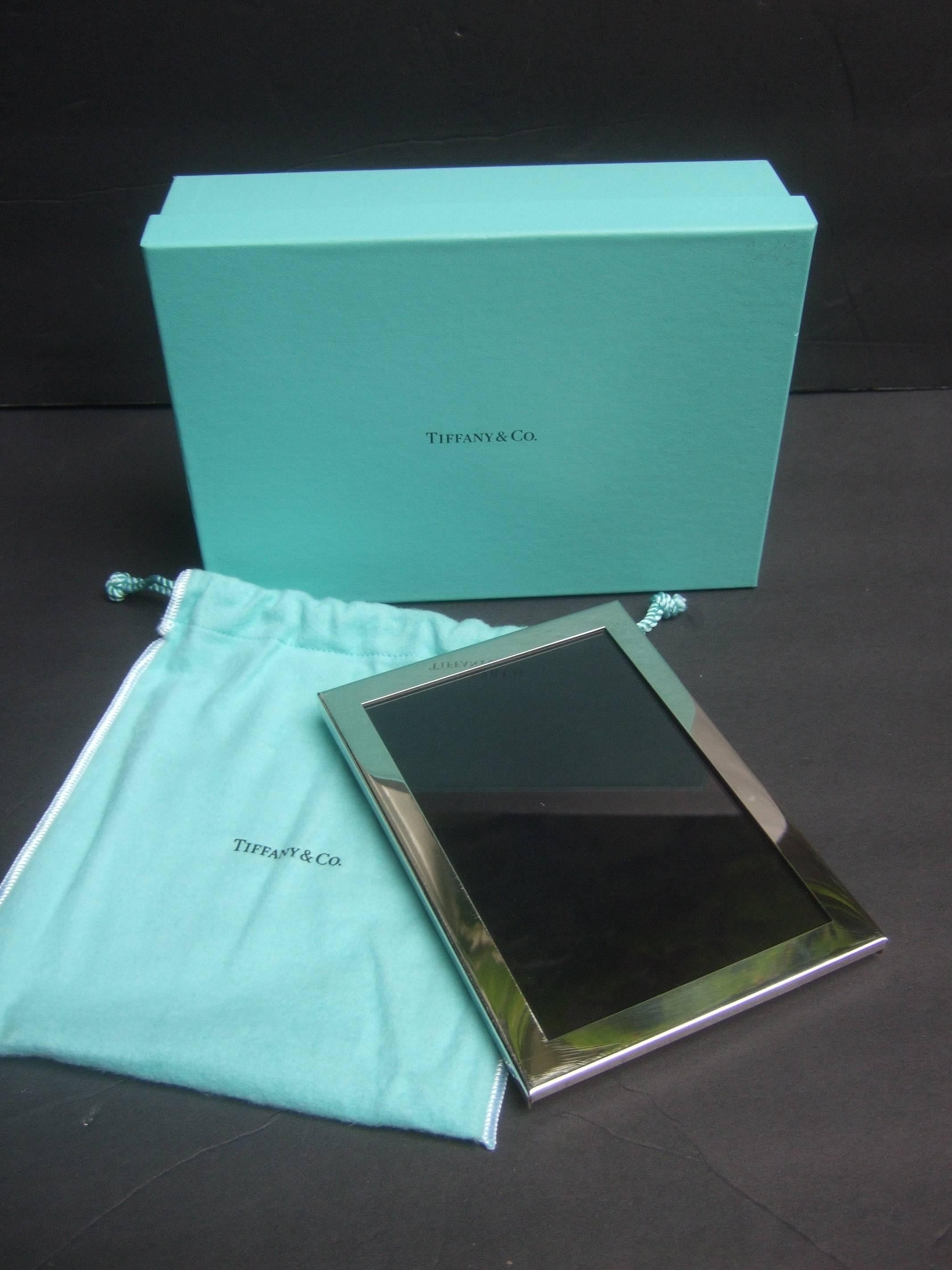 Tiffany and Company sleek chrome photo frame in Tiffany box
The classic picture frame makes an elegant 
timeless accessory

New in the original Tiffany box paired with 
matching Tiffany cloth dust cover pouch  

One of the metal edges is stamped