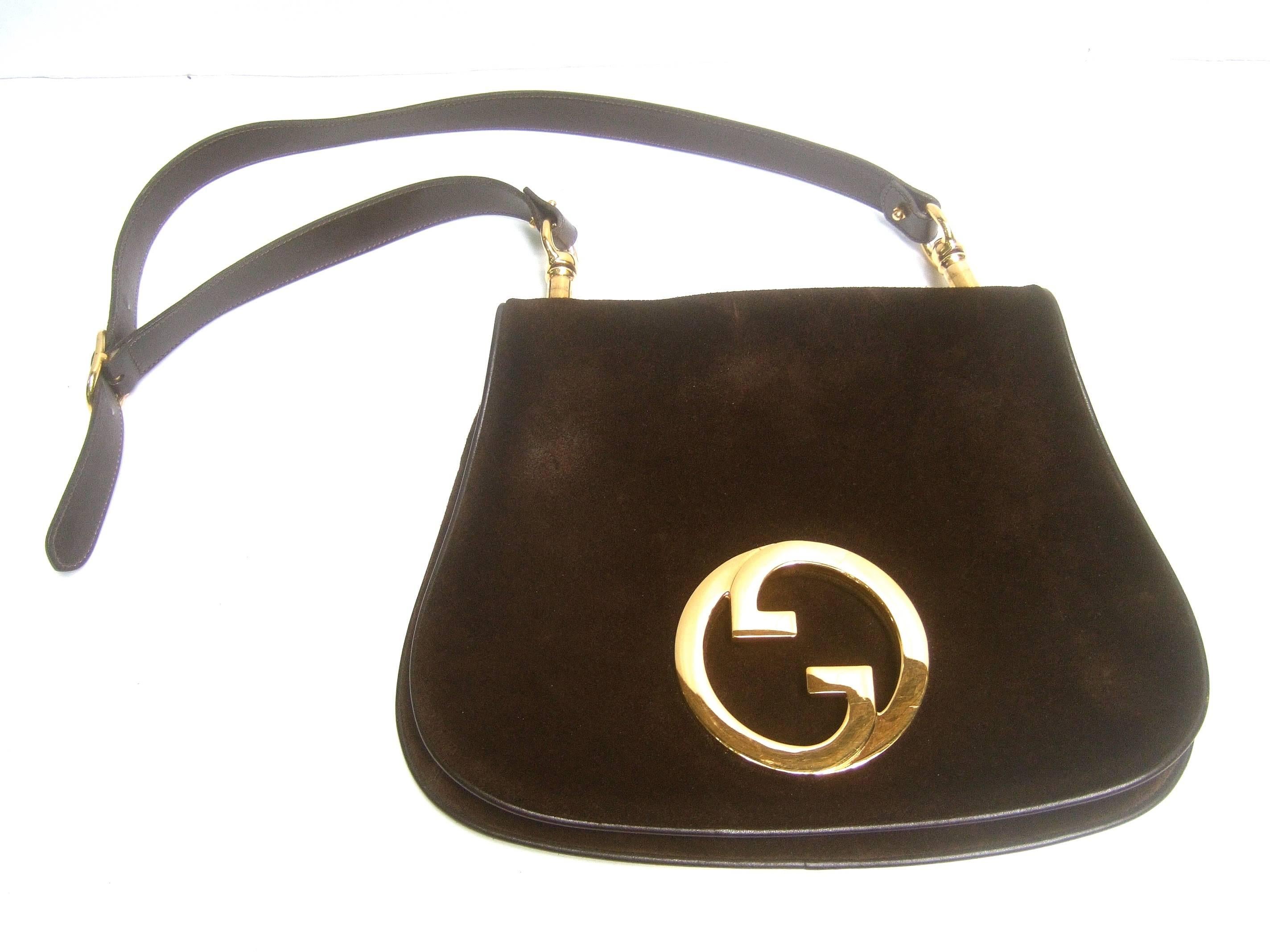 Gucci Luxurious chocolate brown suede blondie shoulder bag c 1970s
The stylish Italian handbag is covered with plush dark brown
doeskin suede 

Adorned with Gucci's massive gilt metal interlocked initials 
Suspended from a dark brown supple