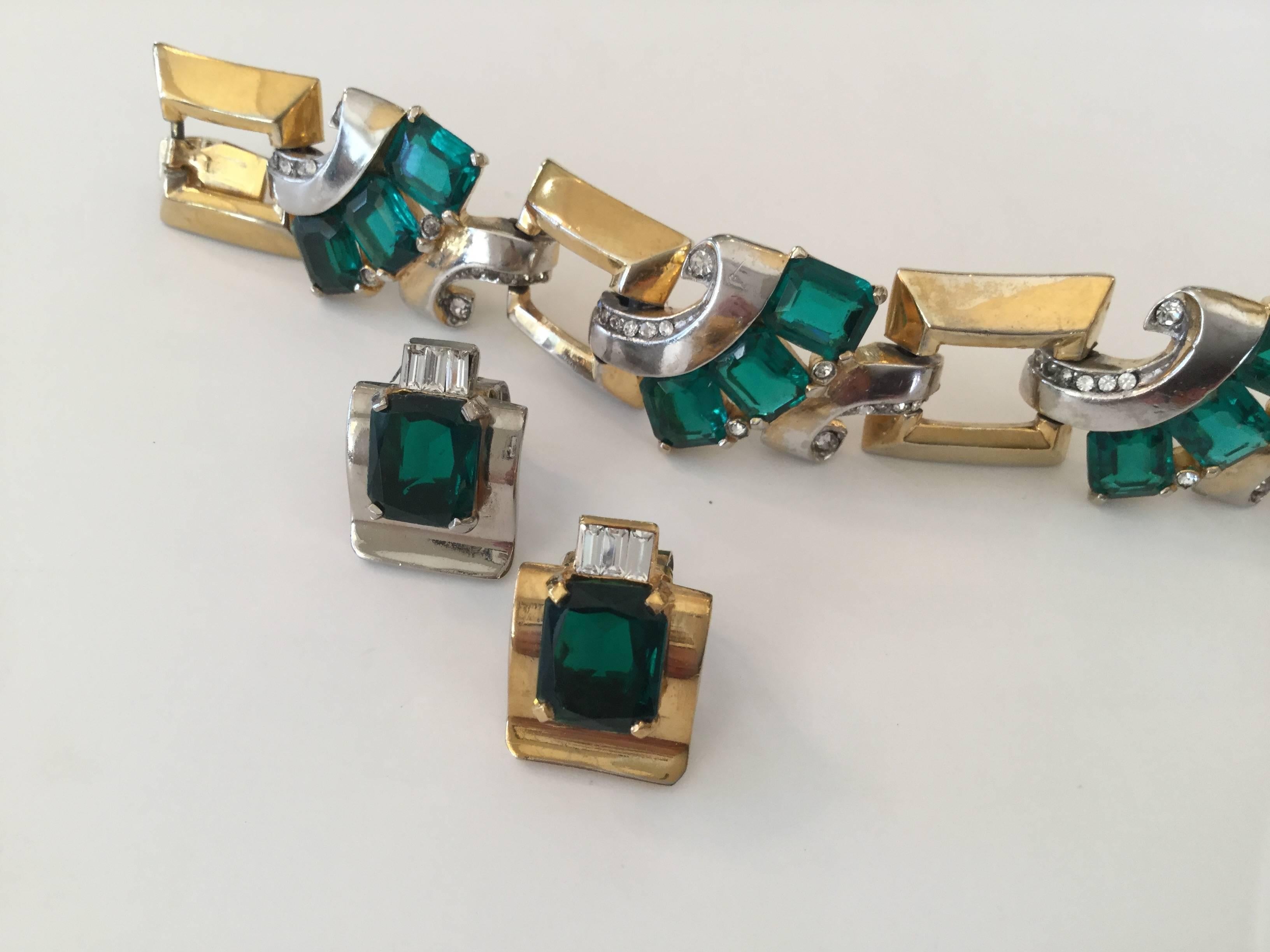 Early Mazer Art Deco emerald green rhinestone bracelet with matching earrings.
Silver and gold plated metal. So clever that the earrings follow this by one being
silver plate and the other being gold plate. Huge emerald paste stones. A bit of