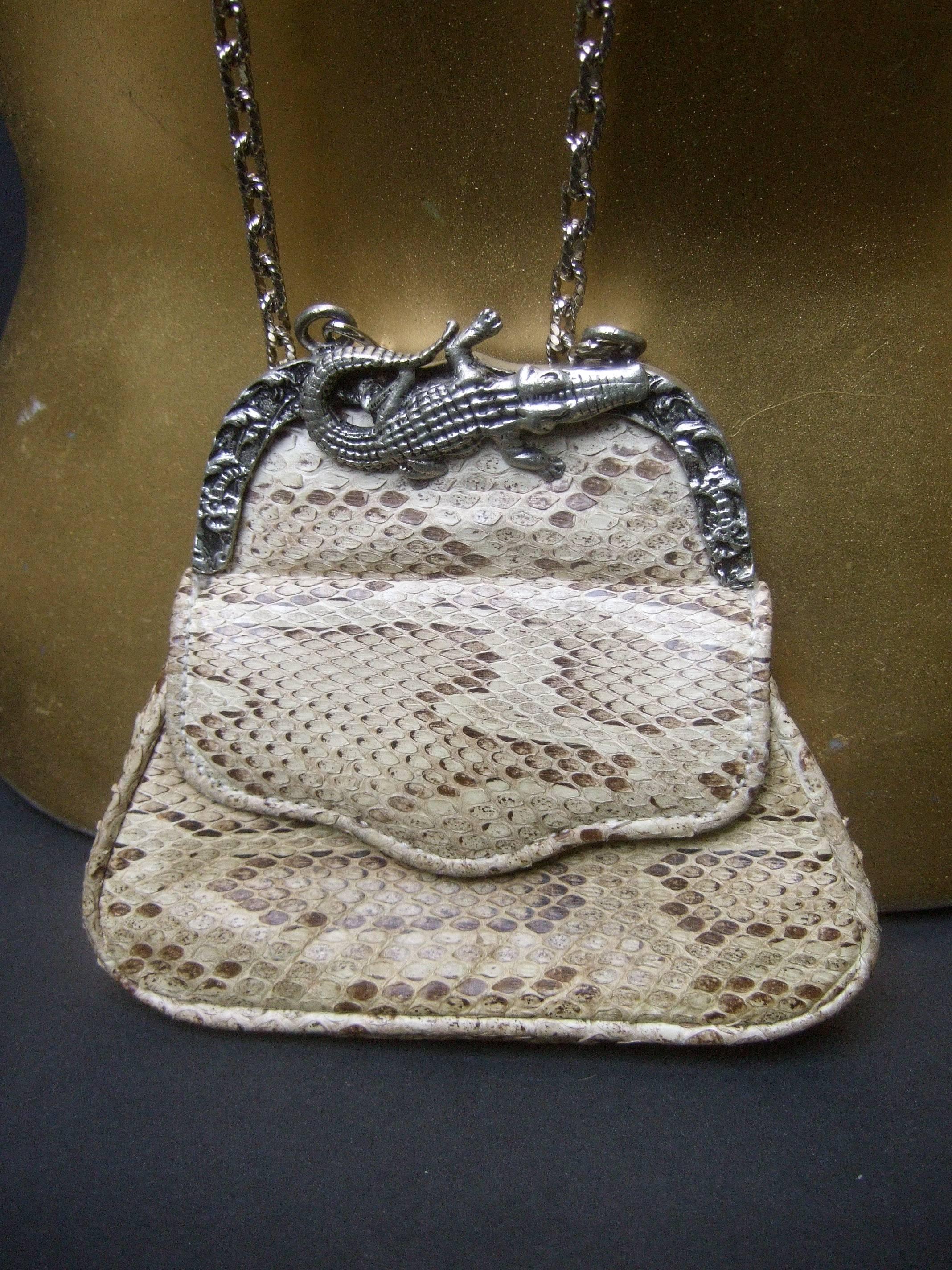 Diminutive python alligator emblem tiny pouch purse
The unique small purse is covered with exotic 
python skin on both exterior sides 

The pewter tone metal clasp frame is adorned with 
an alligator emblem. The tiny coin size purse hangs
from