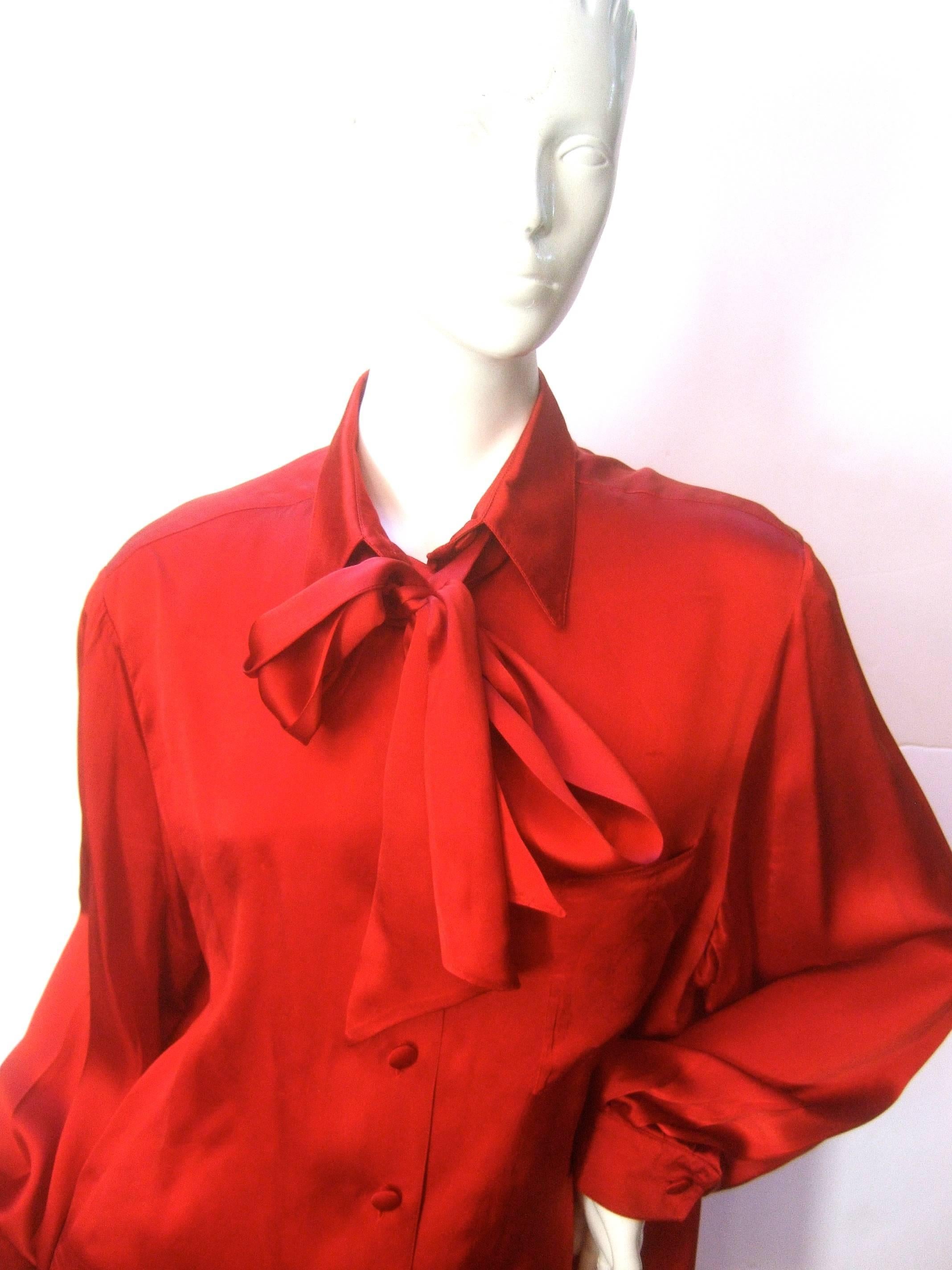 Hermes Paris Sumptuous scarlet silk charmeuse blouse Size 44
The elegant silk blouse is designed with luminous silk;  
paired with a billowy looped bow that can be worn  
tied or draped loose flowing over the shoulders

The single chest pocket