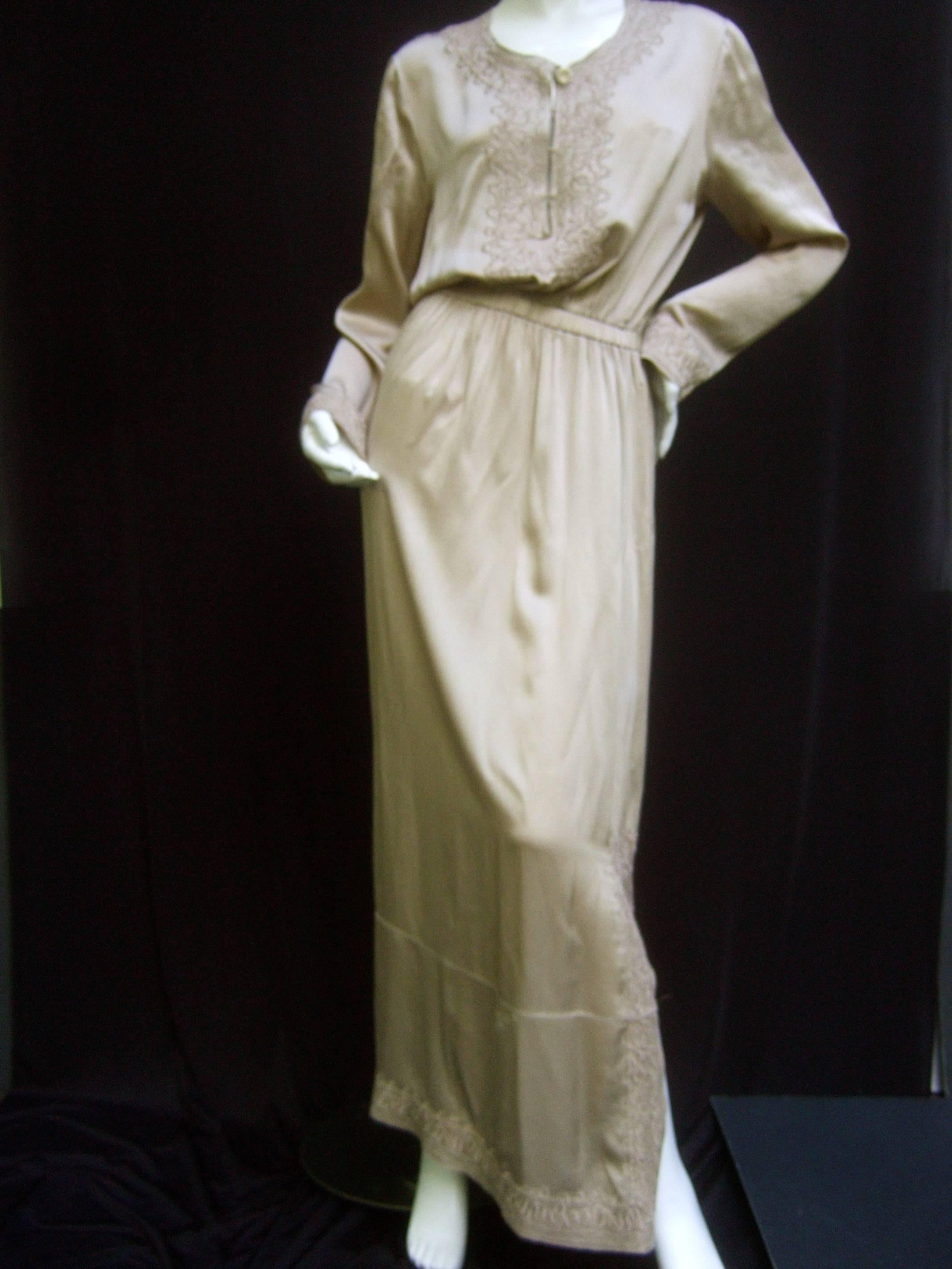 Yves Saint Laurent Rive Gauche embroidered silk gown 
The elegant champagne color gown is designed with 
sumptuous silk. Accented with subtle embroidery that 
frames the neckline, cuffs and extends to the lower sides 
and hemline

The bodice