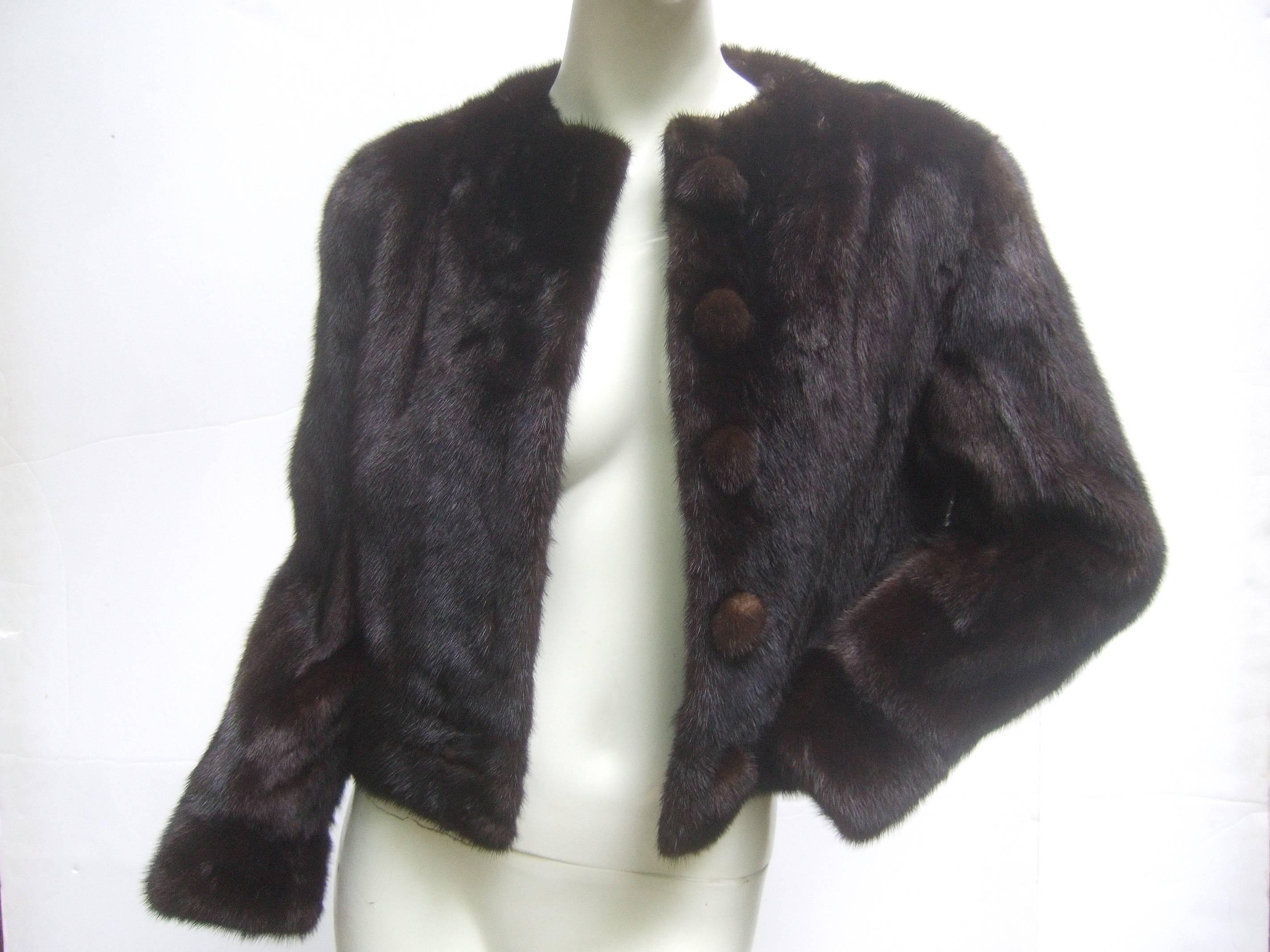 Luxurious mink fur cropped jacket c 1970
The dark brown mahogany jacket is designed
with plush lustrous mink fur

The jacket secures with five large mink 
covered buttons. The interior is lined 
in dark brown satin acetate 

The versatile