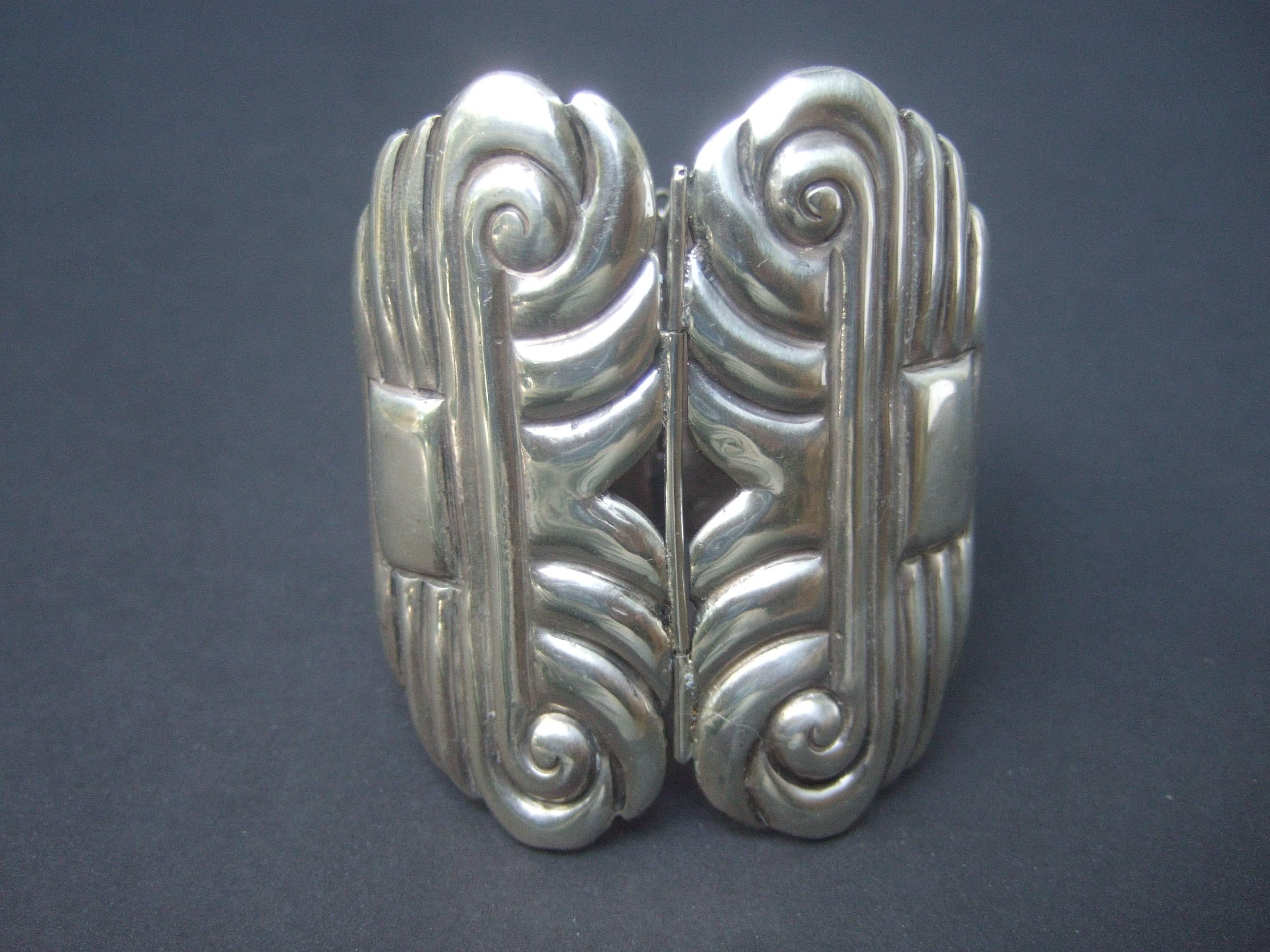 Mexican artisan sterling massive hinged cuff bracelet c 1940s
The huge scale handmade bracelet is designed with 
vertical and horizontal impressed lines accented 
with scrolled detail.The severe design has an art deco
style influence  

The