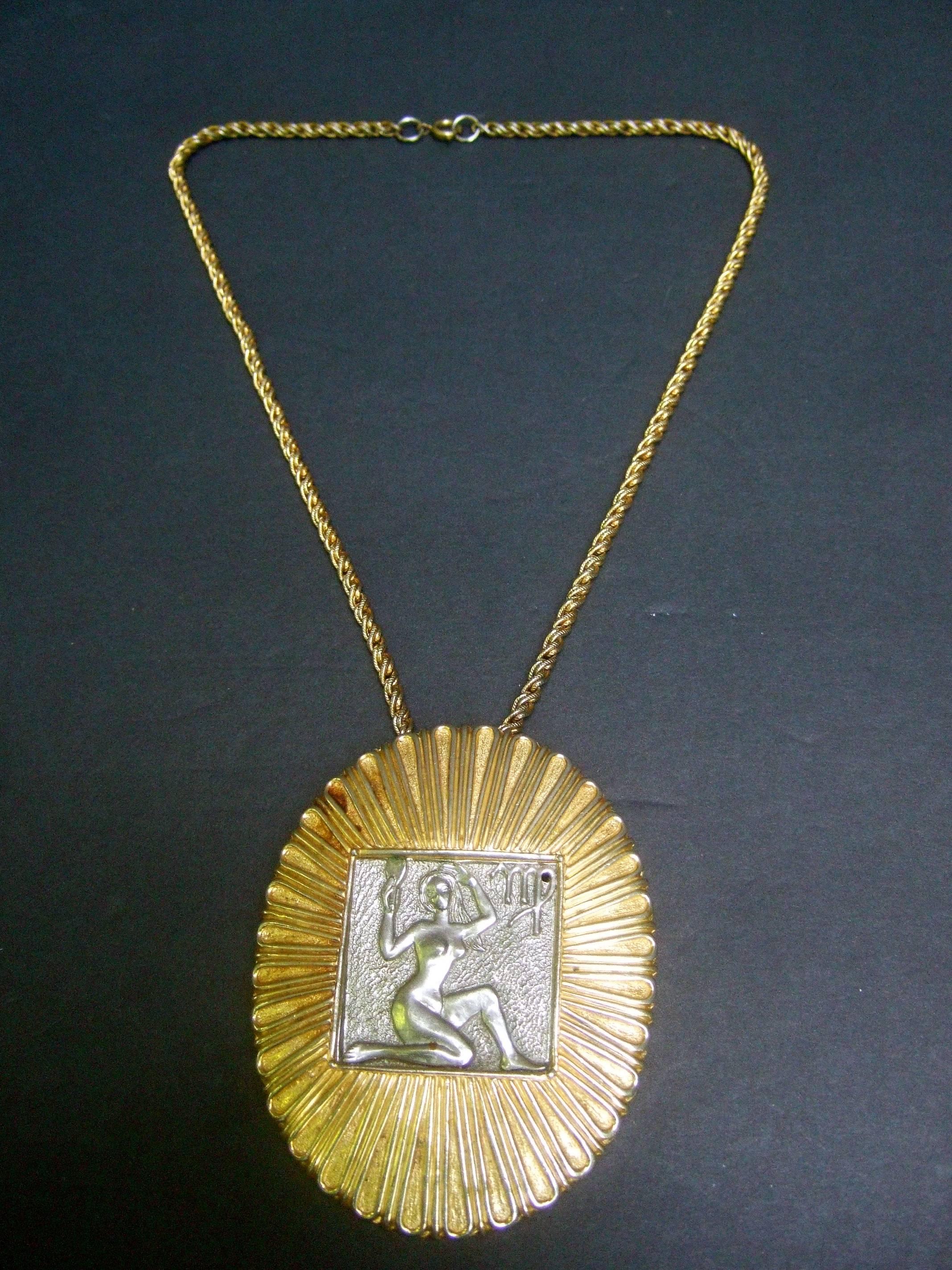 Judith Leiber Figural woman pendant necklace c 1970s
The unique necklace is designed with a female 
nude figure on a silver tone metal recessed plaque 

The versatile design can also be worn as a brooch
The large scale oval shaped gilt pendant