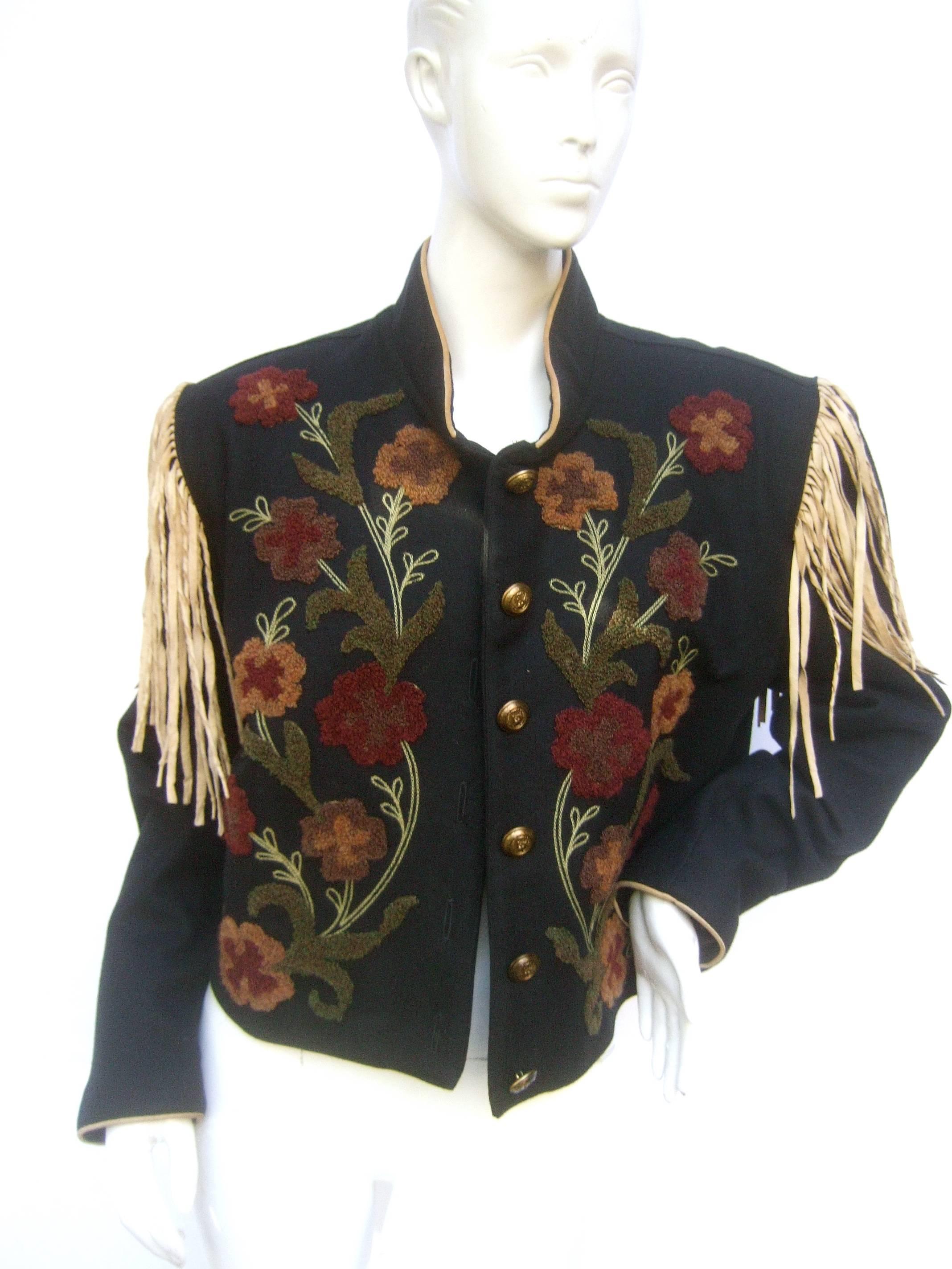 Southwestern black wool applique fringe jacket c 1990s
The unique Southwestern style wool jacket 
is designed with a garden of applique autumn  
earth tone flowers on the front

The shoulders are embellished with long
tan suede fringe tassels.
