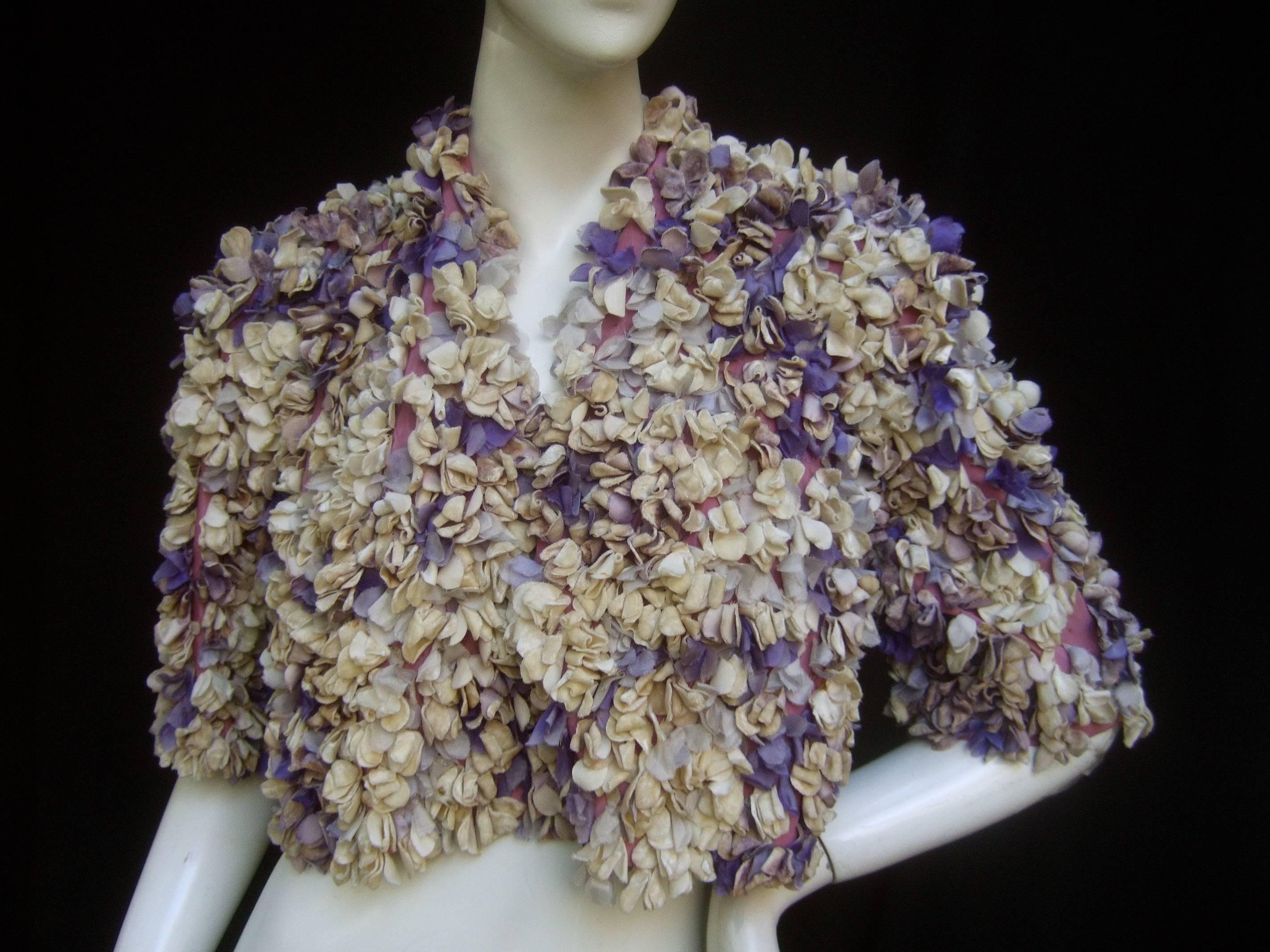 Jean Desses' Couture museum worthy pastel flower pedal jacket c 1950 
The avant-garde couture bolero jacket is embellished with a contiguous 
field of hand sewn pastel flower pedals

The silk & velvet flower pedals range from white, lavender