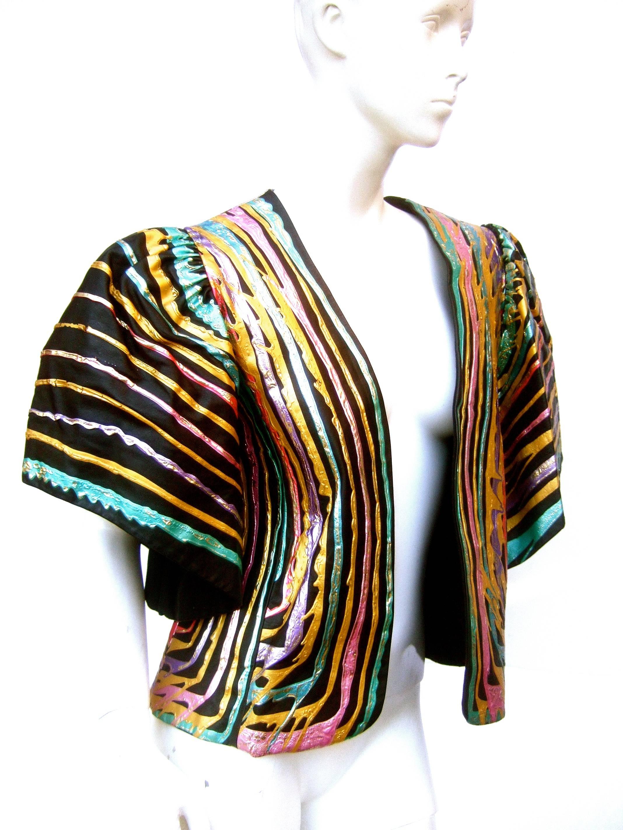 Artisan black leather metallic hand painted jacket c 1980s
The edgy unique leather cropped jacket is designed
with vibrant gold metallic & pastel enamel stripes  
& splatter print graphics on the back side 

The hand painted stripes are