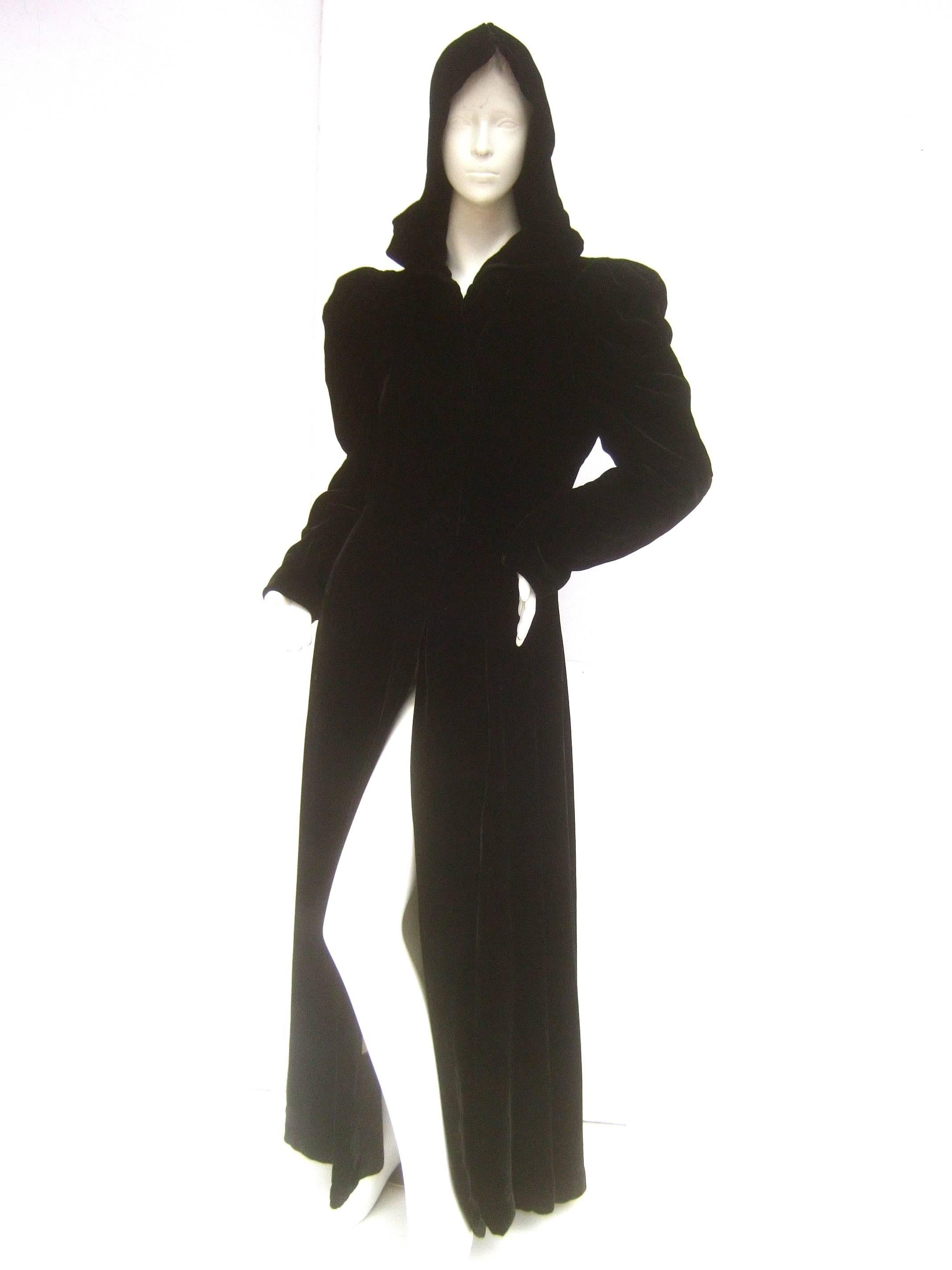 Dramatic black silk velvet hooded opera coat c 1950s
The elegant long sweeping silk velvet coat 
is designed with sumptuous black silk velvet 

The versatile design can be worn with the 
hood placed over the head; it too can be
lowered &