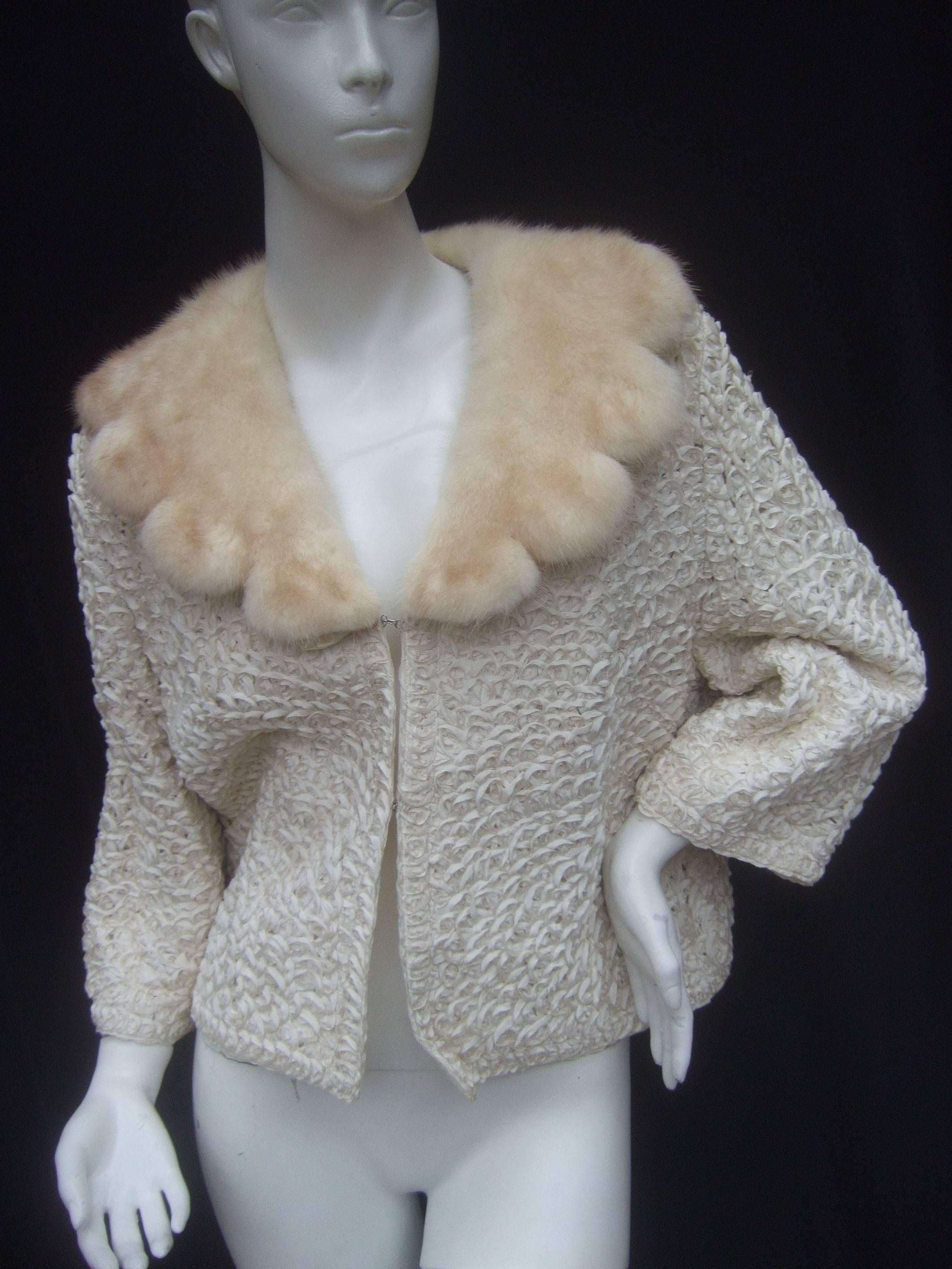 Opulent mink collar ivory ribbon jacket c 1960s
The stylish retro boxy ribbon knit jacket is paired 
with a sumptuous blonde scalloped milk collar 

The jacket is designed with intricate woven 
ivory color ribbons throughout. The interior
is
