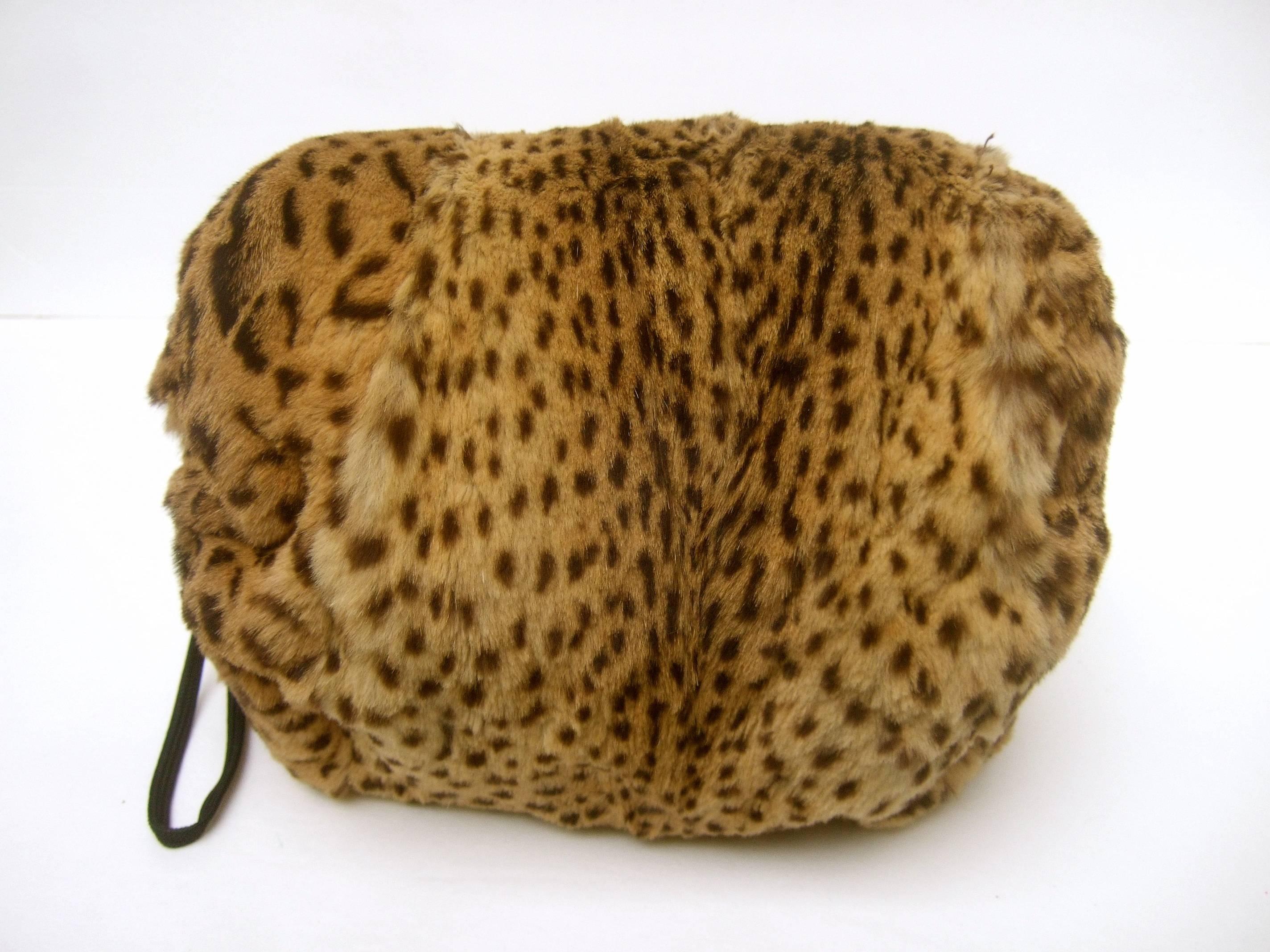 Exotic animal print stamped fur muff c 1950s
The stylish retro fur muff has an animal 
fur print design on both exterior sides

Lined in black satin with a string cord 
on one end

Makes a very unique dramatic accessory 

Measures 9.5 inches side to