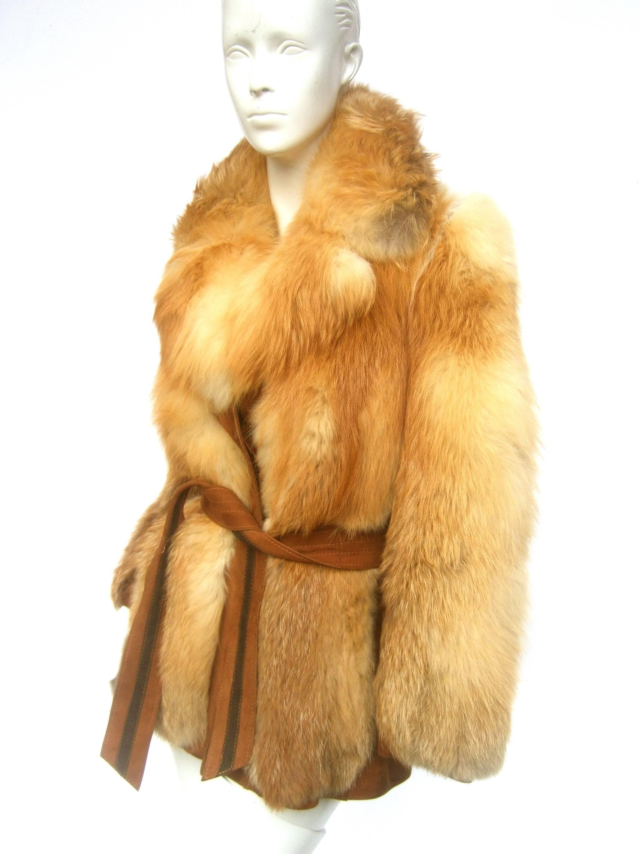 Revillon Paris plush fox fur belted jacket ca 1970
The fluffy dyed fox fur has a rust brown hue 
Designed with a dramatic voluminous collar 

The belt, sleeves and sides are juxtaposed
with soft light brown suede panels and cinched
belt tie. The