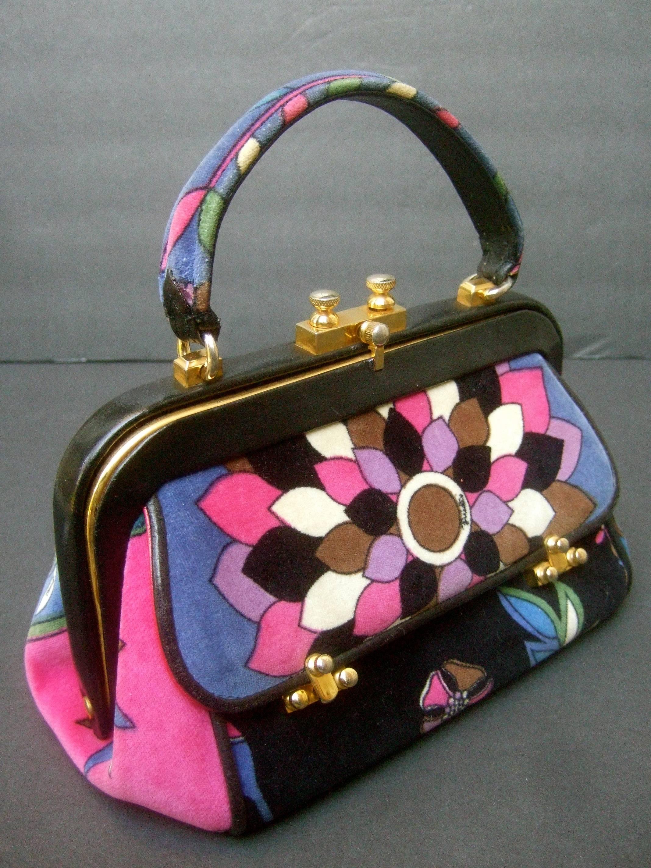 Emilio Pucci Rare velvet leather trim handbag ca 1970
The posh Italian handbag is covered with plush
cotton floral print velvet 

The velvet covering is illustrated with a mosaic 
of vibrant bold graphics with floral motifs
Emilio's script name is
