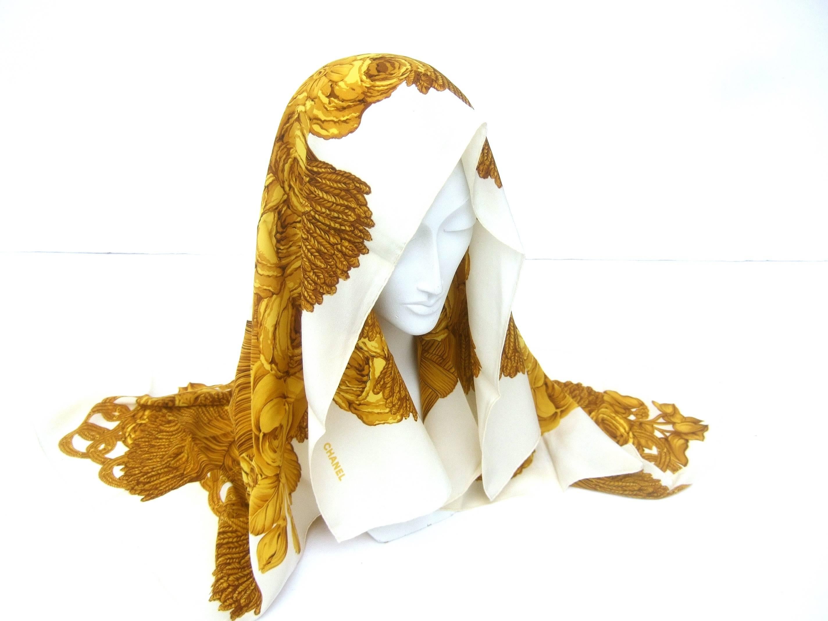 Chanel Luxurious golden silk rose scarf ca 1990s
The elegant scarf is infused with a wreath 
of golden yellow roses surrounded with 
golden braided rings with Chanel's C.C.
initials  

Accented with bands of golden wheat stalks
The golden yellow