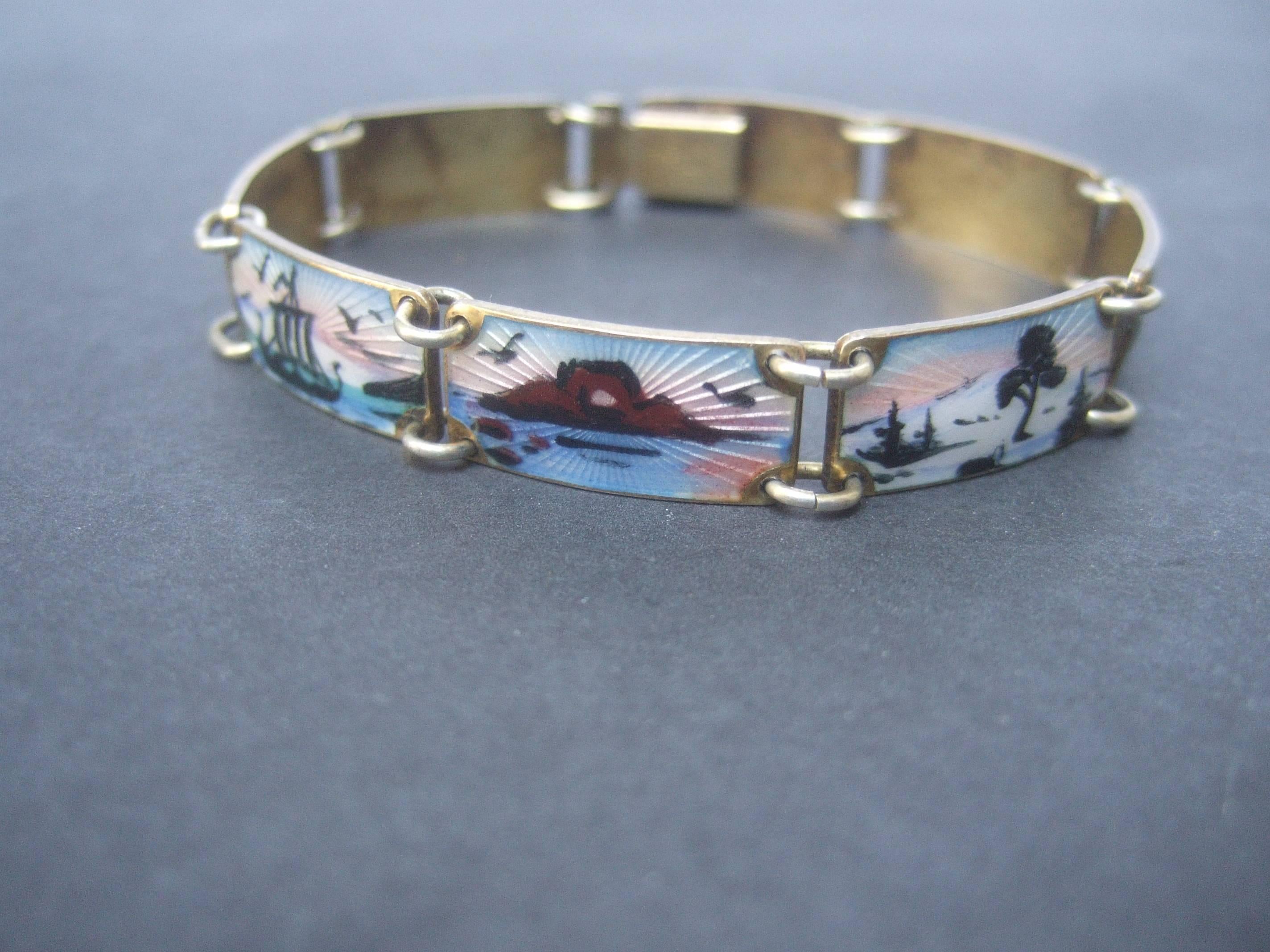 Norway sterling silver guilloche enamel link bracelet ca 1960
The unique artisan cloisonné enamel bracelet is designed
with a series of hinged scenic links

The sterling enamel links depict various scenes of sailing 
ships, a deer pulling a sled, a