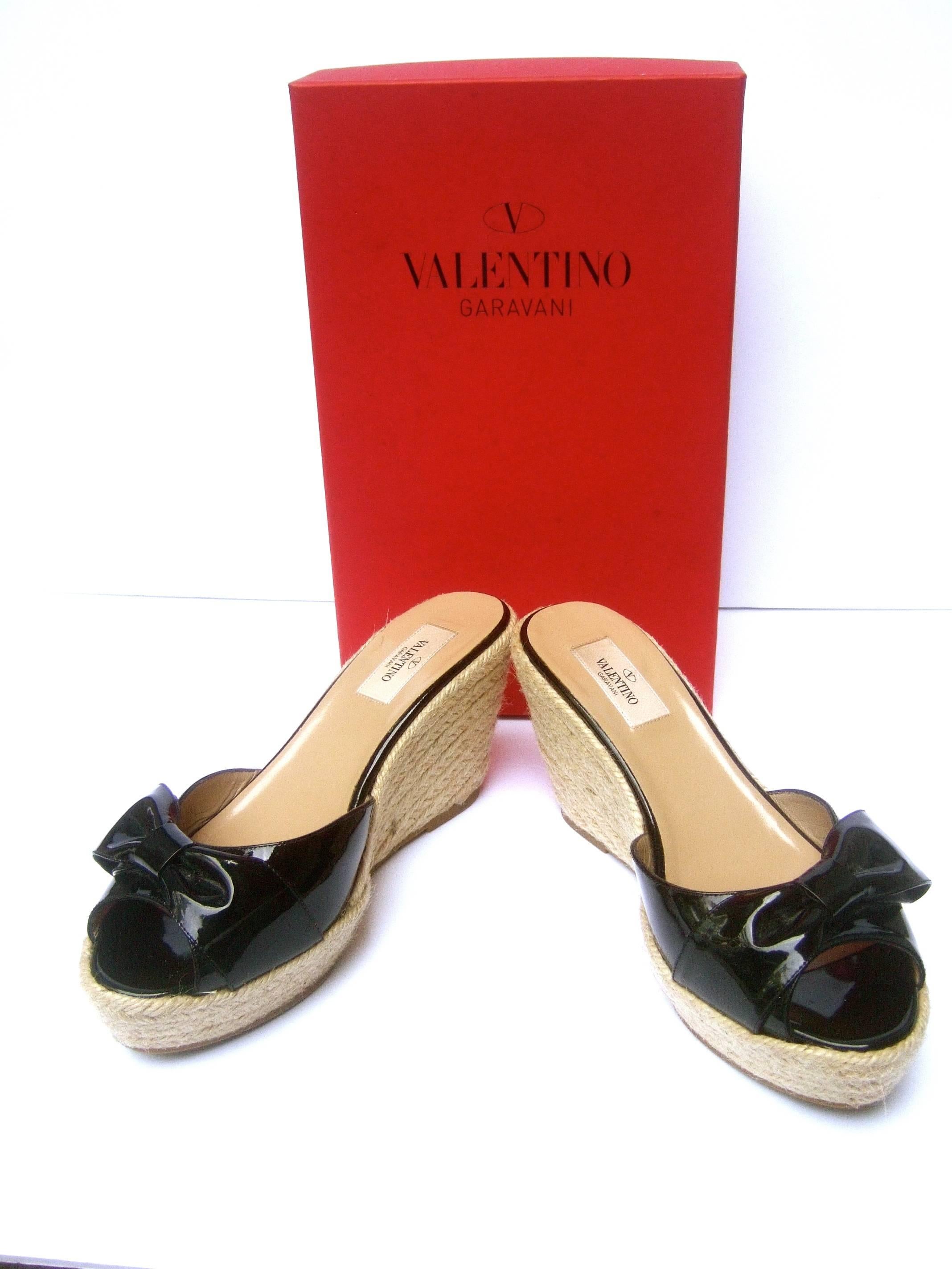 Valentino Italy black patent leather wedge rope sandals Size 40 
The stylish open toe sandals are designed with glossy black
patent leather with a large matching bow on each shoe 

The platform wedge heels have a braided rope covering
Makes for a