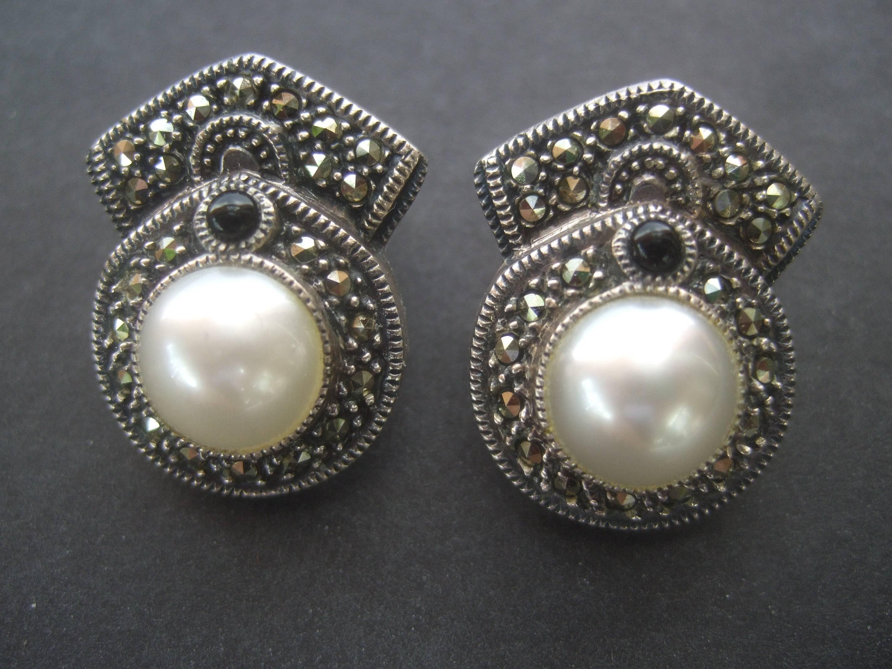 Judith Jack Opulent sterling marcasite pearl earrings
The elegant sterling clip on earrings are encrusted 
glitterling marcasite crystals

The center is adorned with a glass enamel pearl
with a single jet crystal. The designer earrings 
while