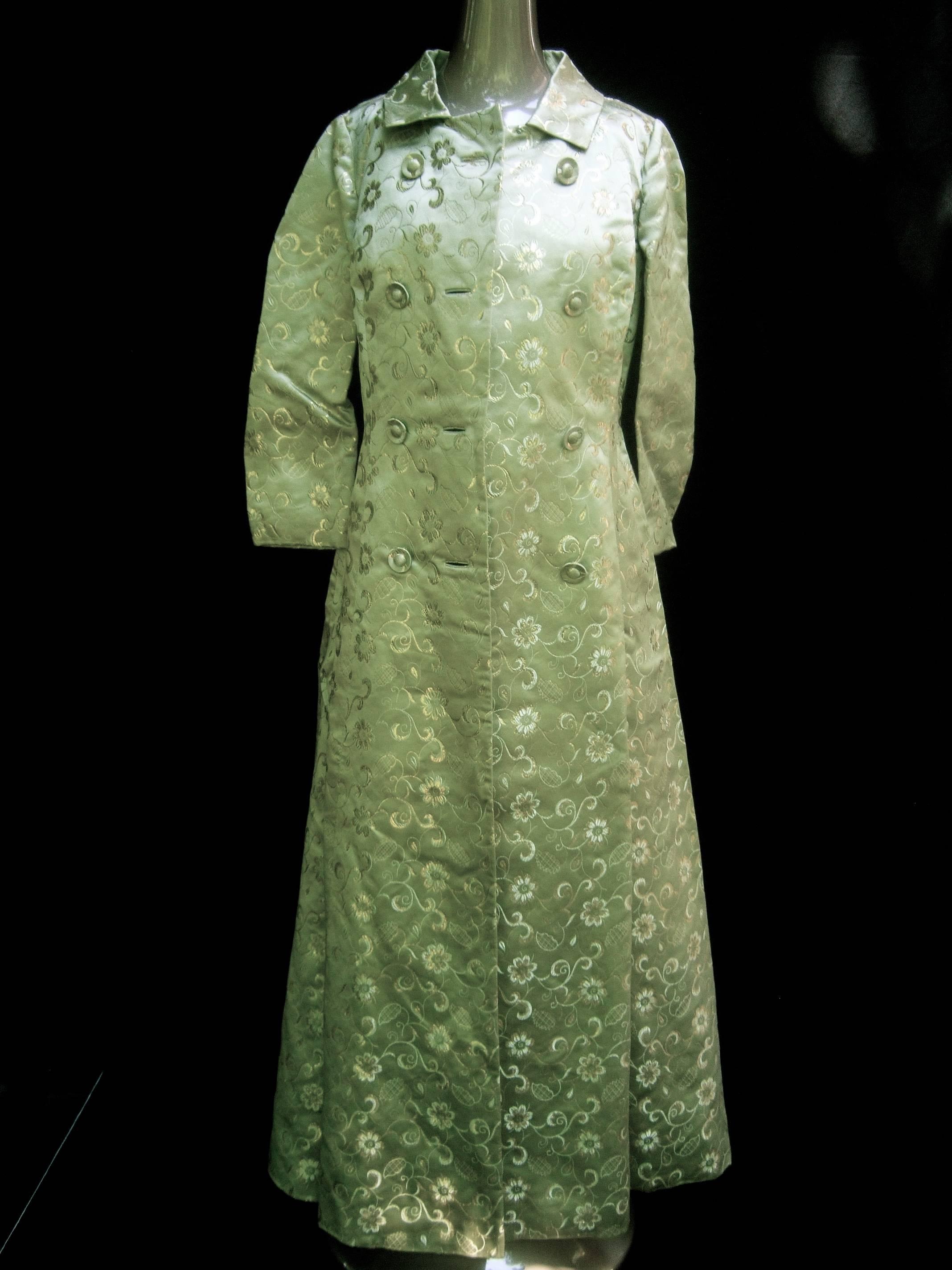 Opulent mint green satin brocade opera coat ensemble ca 1960s
The sweeping pale green brocade evening coat is designed
with luxurious satin brocade fabric with gold metallic floral
motifs. The exquisite fabric has an Asian style influence  

Paired