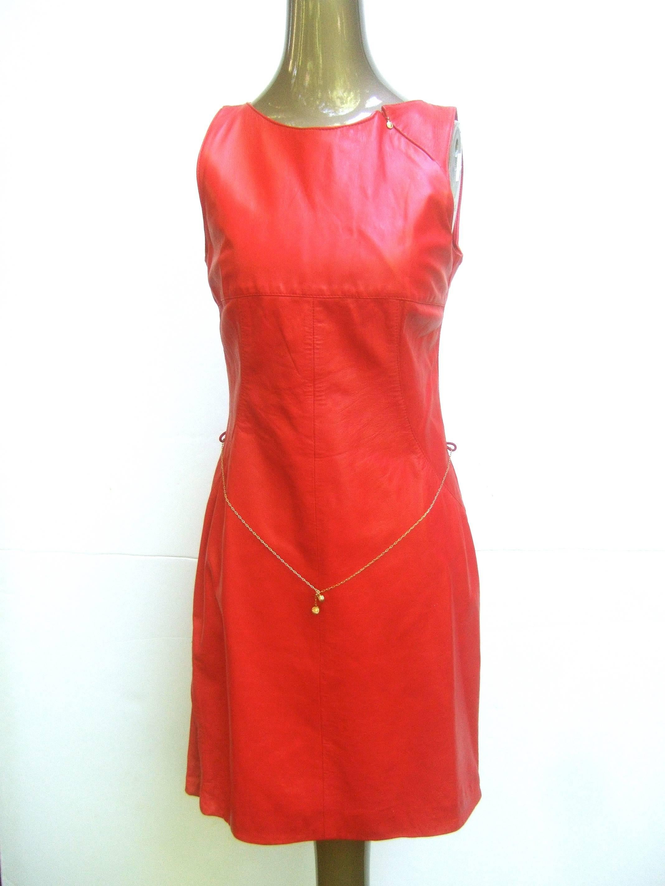 Exciting cherry red leather body hugging sleeveless dress. High impact.
Delicate gilt chain belt adorned with subtle Medusa heads. Flirty zippers
at the hem and shoulder also sporting gilt mini Medusas. Very good vintage condition.  Labelled Versace