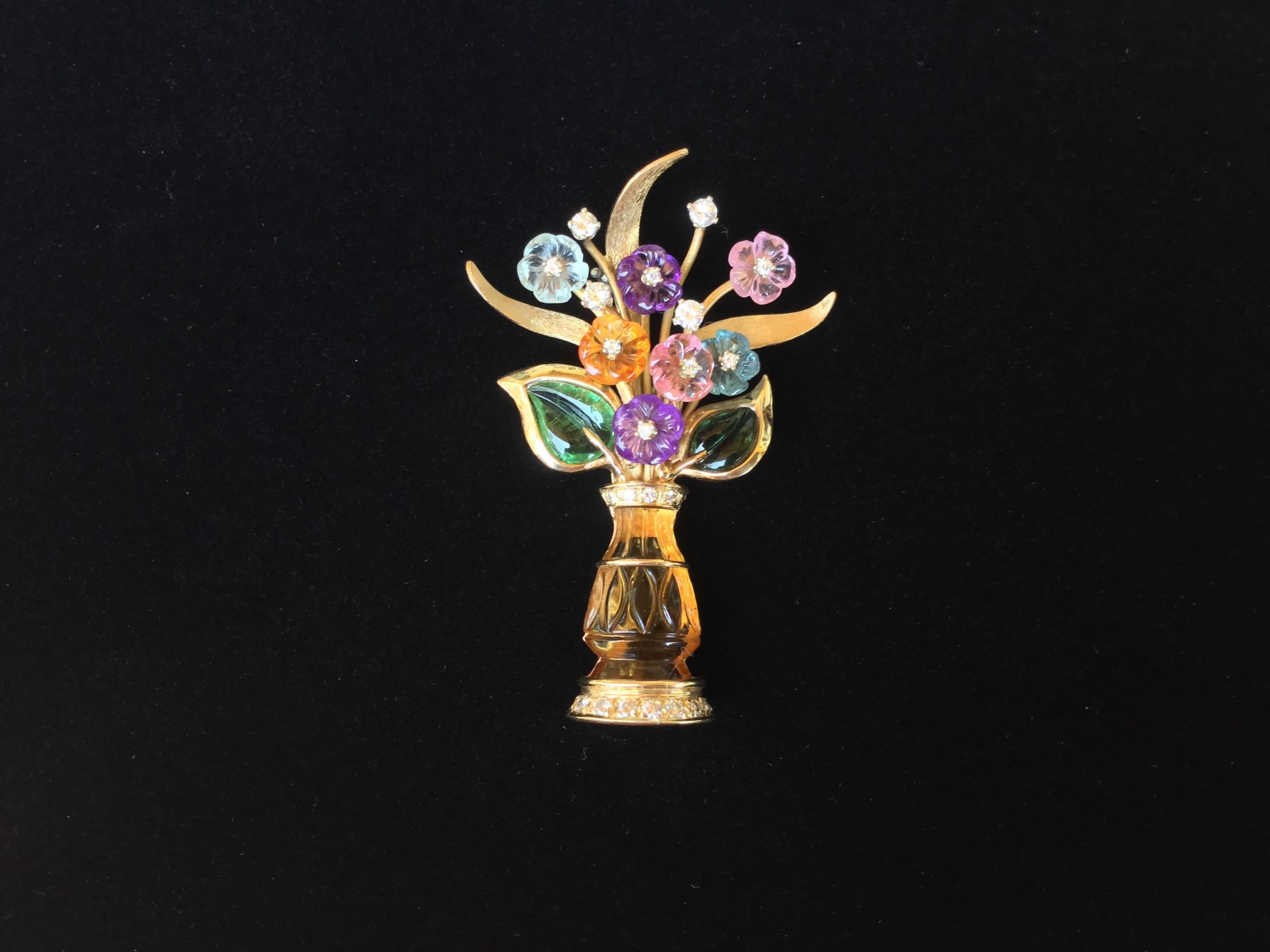 Truly splendid three dimensional 14K gold brooch depicting a vase of flowers. This classical styled vase is made of carved citrine and the blooms and leaves are made of carved green tourmaline, pink tourmaline, amethyst, aquamarine, crystal,and blue