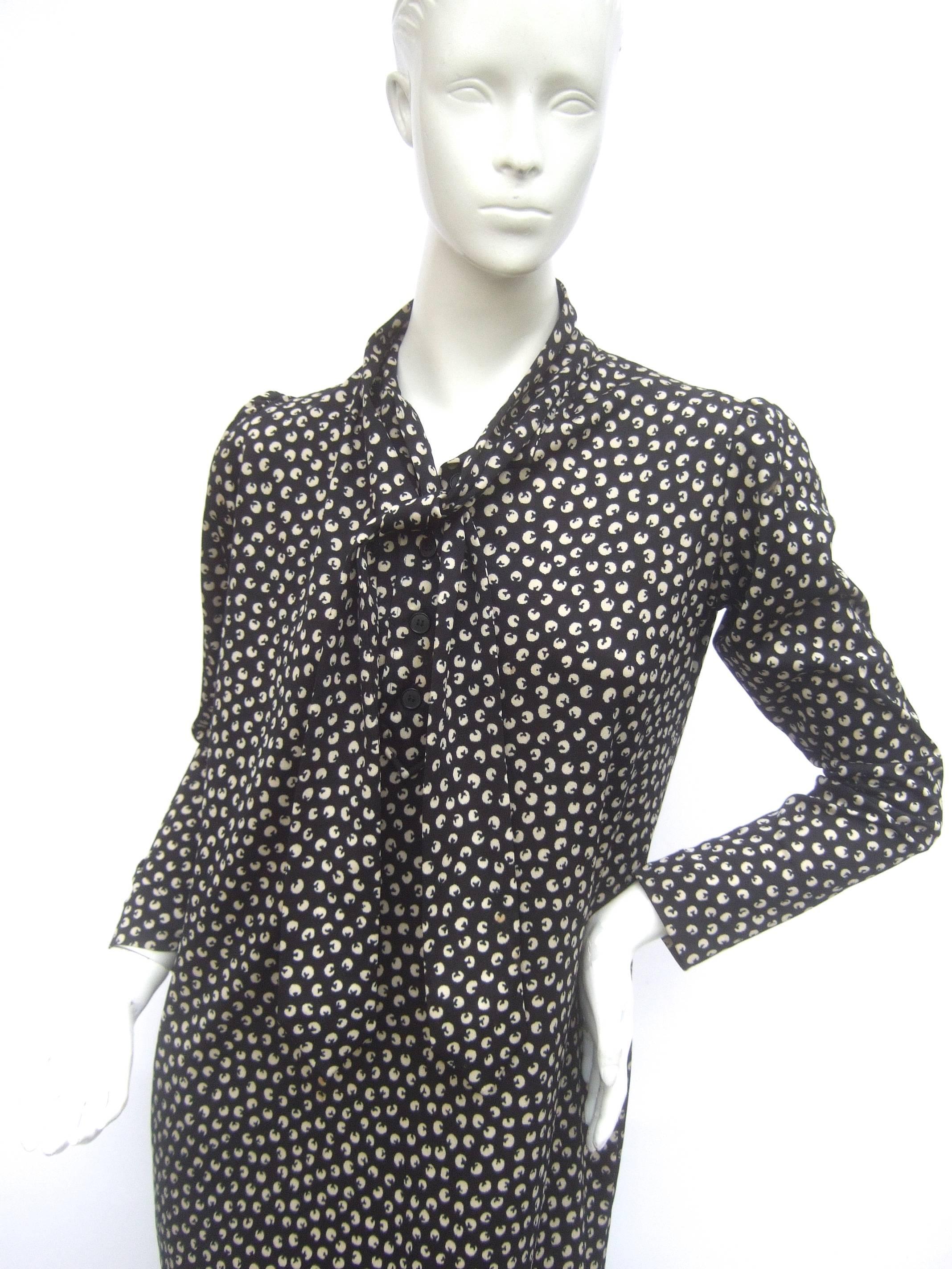 Saint Laurent rive gauche chic black and white print shirt dress c 1970s
The stylish poly knit print dress is designed with a stationary 
tie around the neck. It can be knotted into a bow or worn 
loose around the shoulders. The shoulders have a