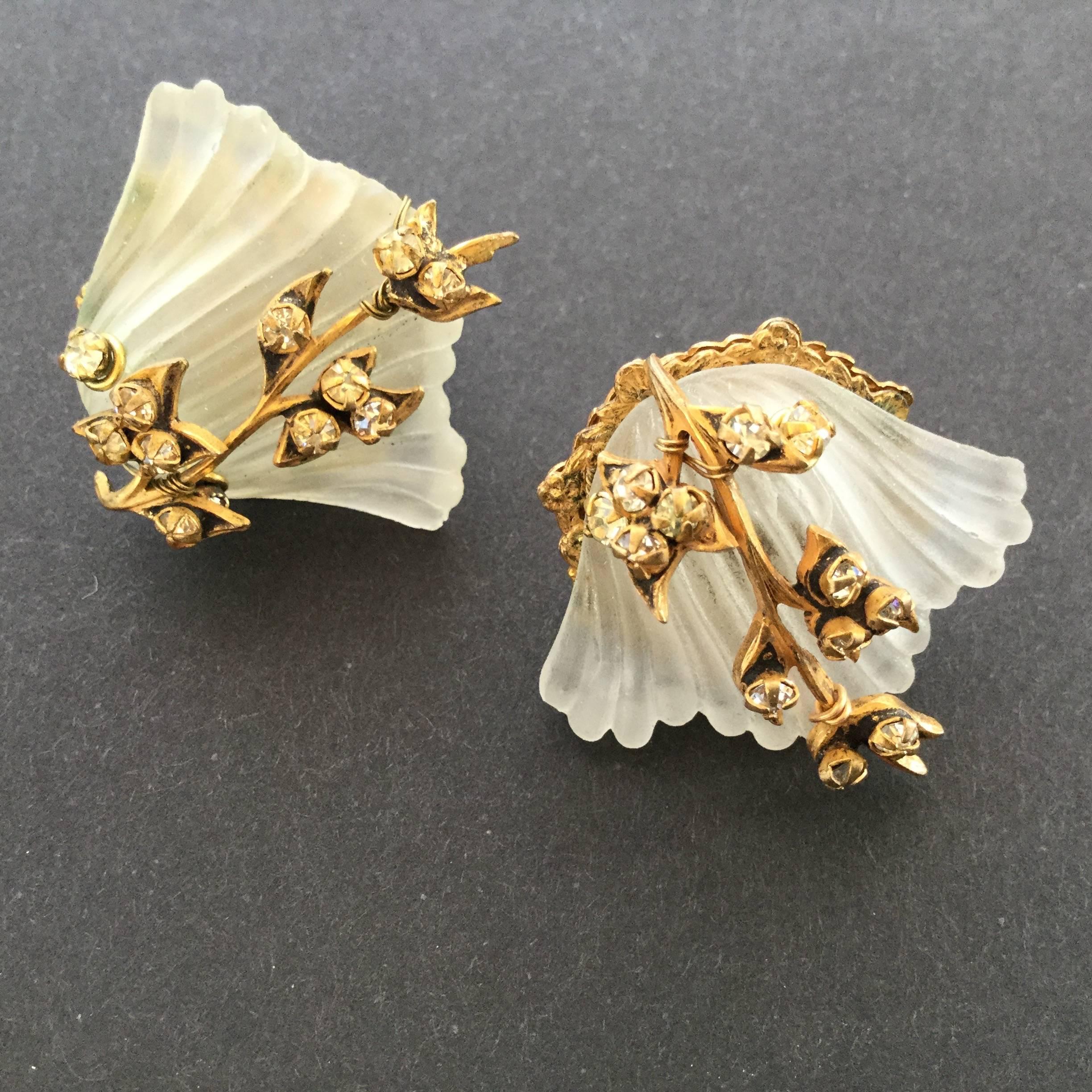 Incredibly romantic Miriam Haskell sea shell earrings of fluted frosted glass
scallops decorated with a floral garland of rose monte crystal pastes. Wired by hand. Excellent condition with all pastes present and earring backs nice and tight. These