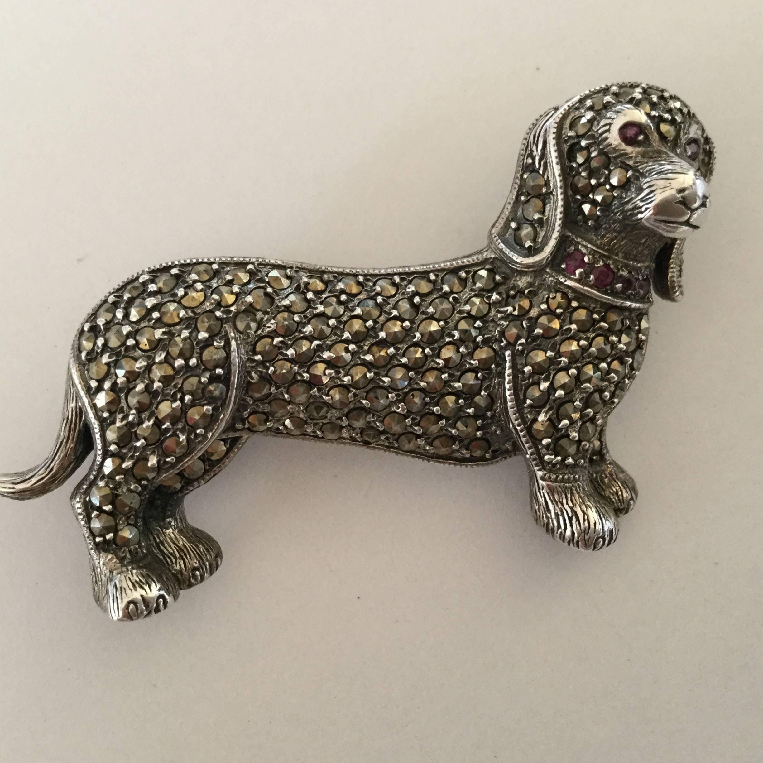 Edwardian revival 1980's marcasite and sterling silver dashshund brooch.
Wonderfully detailed design. Expressive, contemplative little face decorated with garnet eyes and a garnet collar. Note the floppy ears and fuzzy paws. Just adorable!  Really