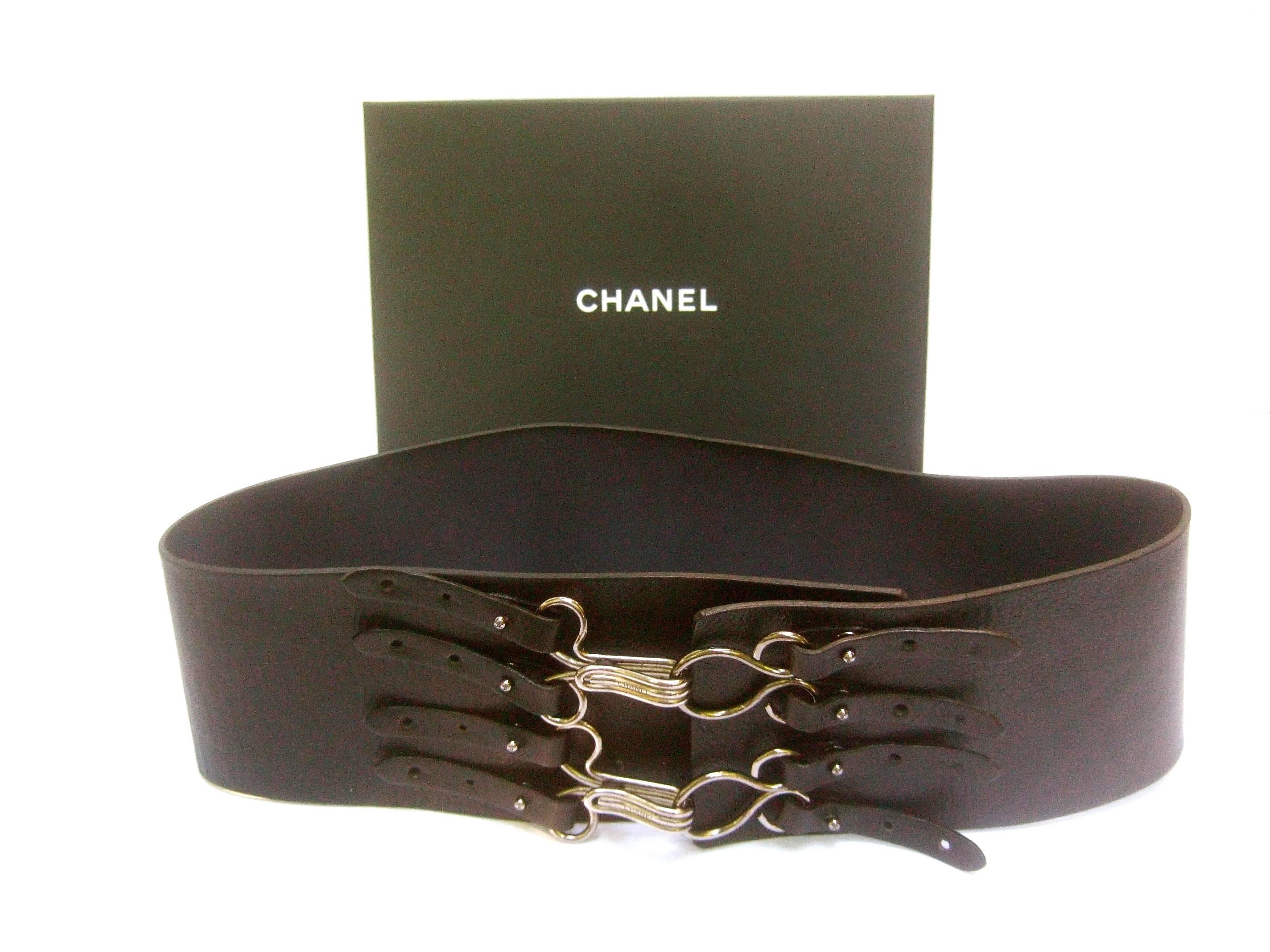 Chanel bold wide black leather belt in Chanel box 
The stylish high fashion belt is designed with a pair
of large silver metal clamps. Each clamp is inscribed 
Chanel 

The unique design allows the silver metal magnetic 
clamps to adjust over three