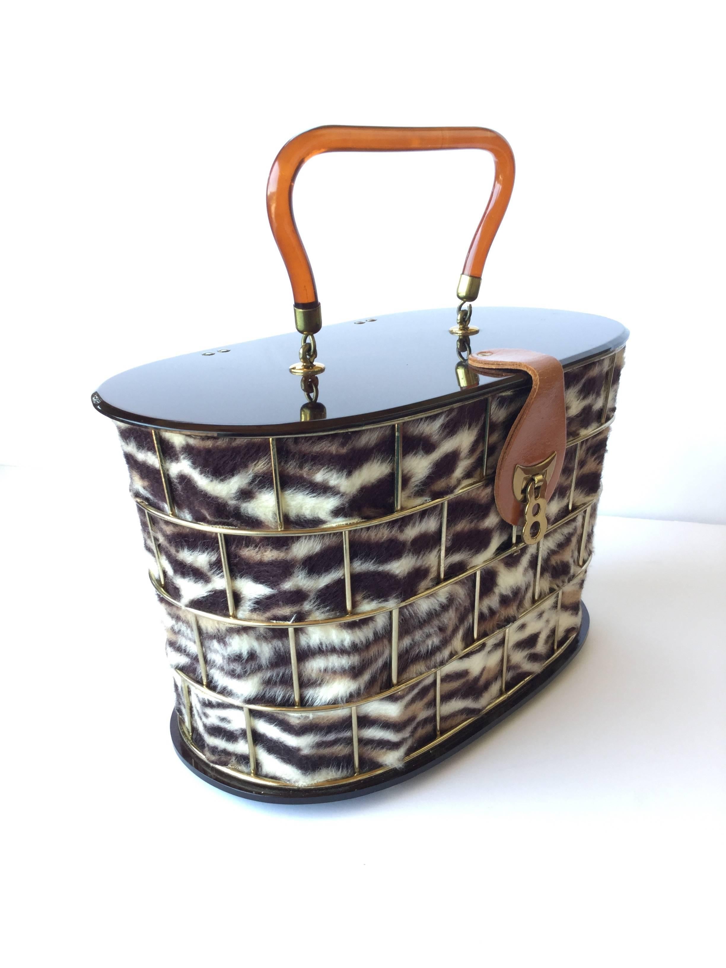 Fantastic 1950's Dorset Rex handbag with furry faux leopard strips weaving
through a gilt metal cage frame. Shiny chocolate brown lucite top and bottom. 
Graceful honey colored lucite handle. Leather and gilt clasp. Lined in silky peach satin.  This