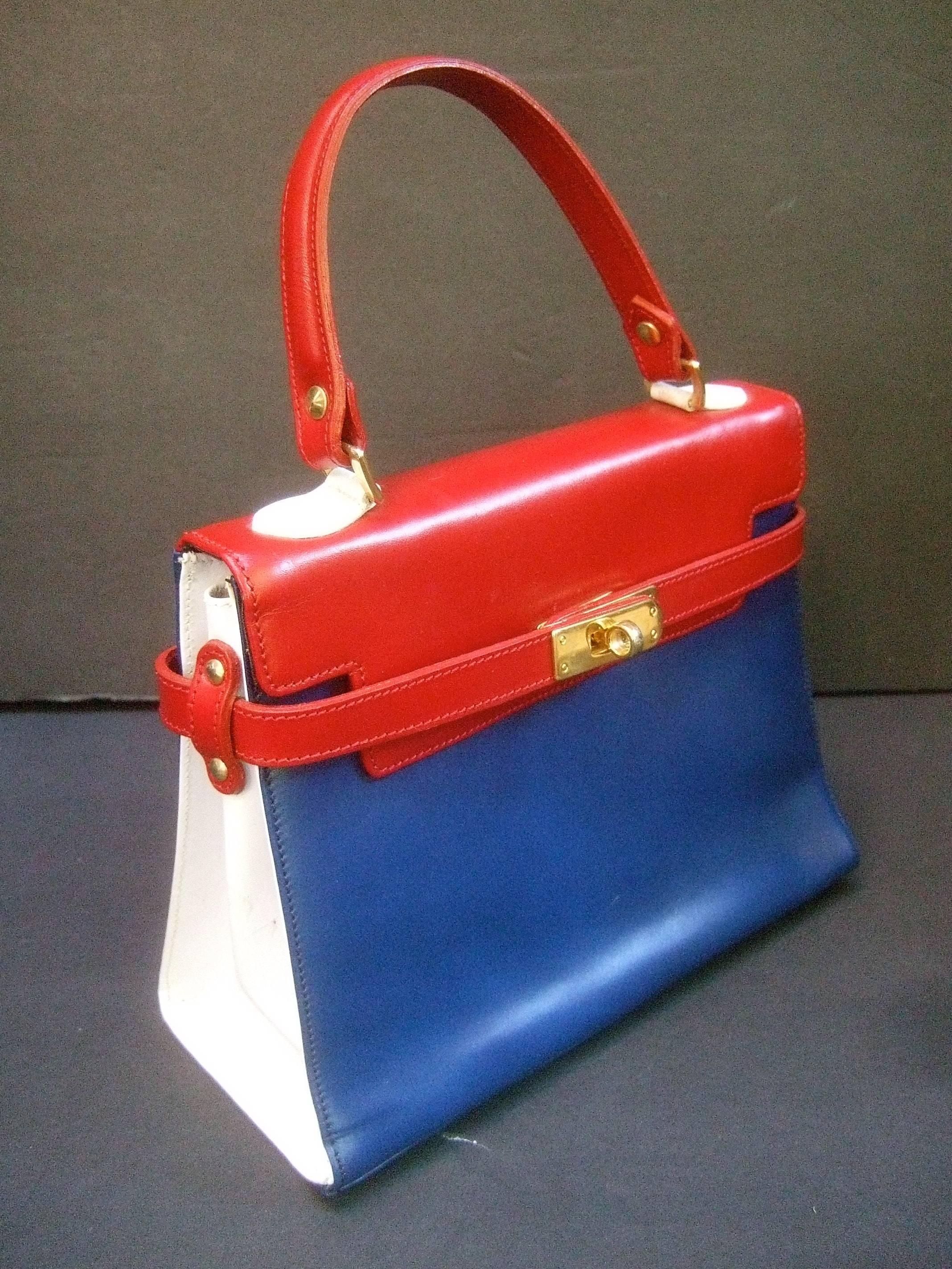 Chic mod Italian leather handbag c 1970
The stylish retro handbag has a classic
design with a twist 

The red, white and blue leather covering 
makes for a stylish unique accessory 
Adorned with sleek gilt metal hardware

The interior is lined in