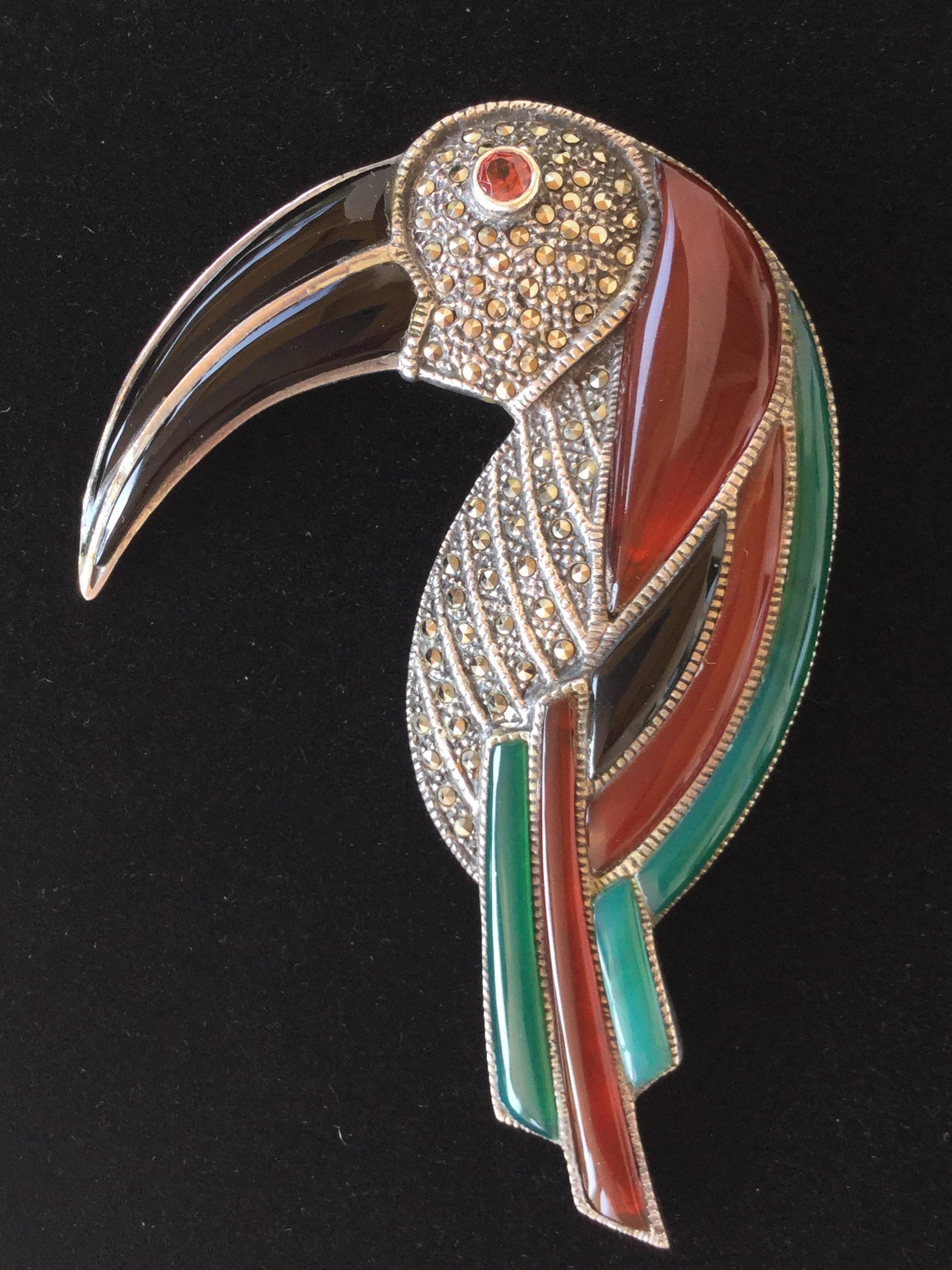 This large scale Deco Style sterling silver toucan brooch is made of beautifully translucent carnelian, chrysoprase, and onyx segments accented with sparkling marcasites.  The detail and quality is just amazing right down to it's genuine garnet eye.