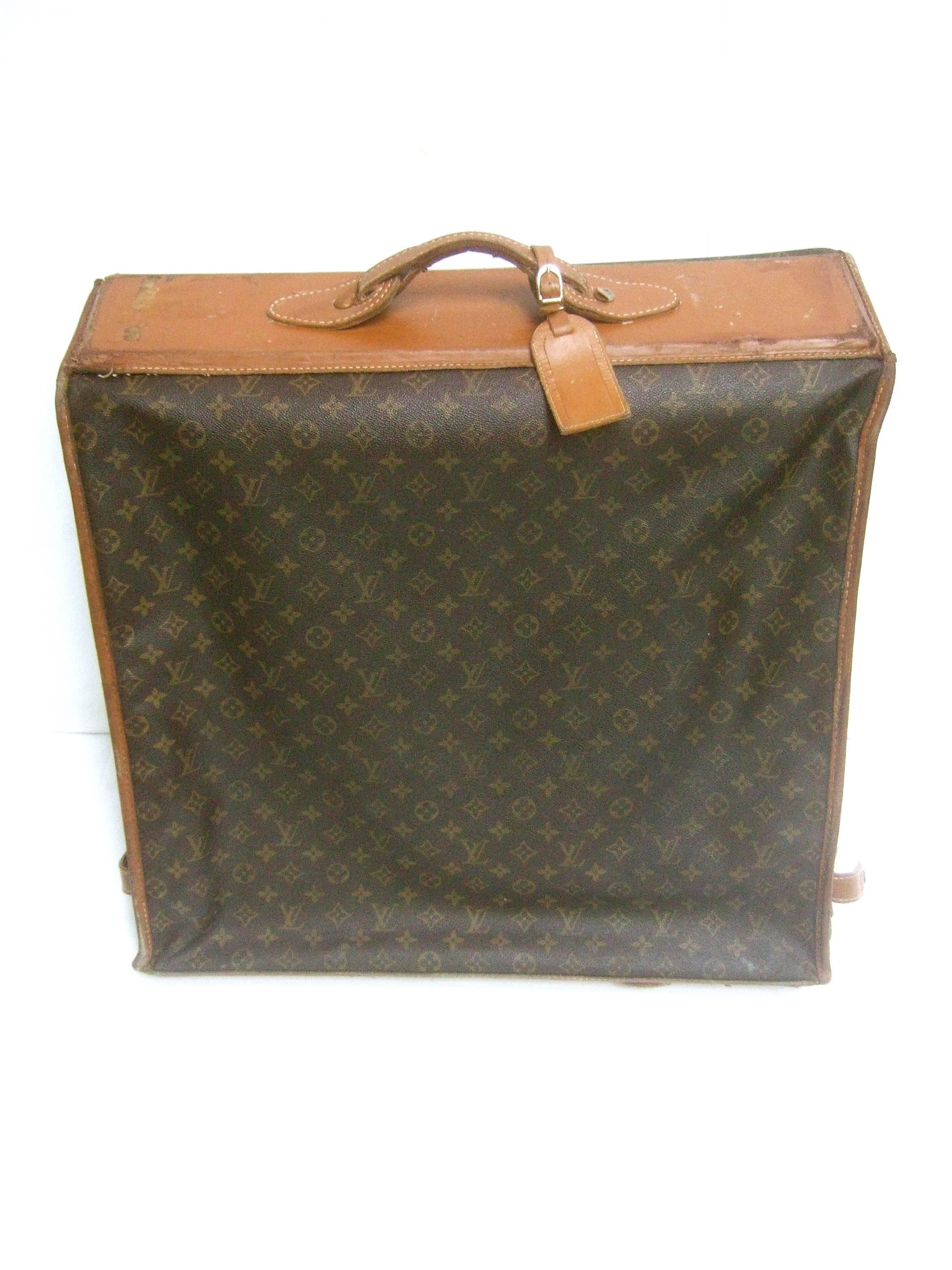 Louis Vuitton Shabby chic well loved garment travel case c 1970s
The stylish retro travel luggage is designed with 
Louis Vuitton's signature brown coated canvas 
covering with L.V. initials repeated throughout  

The top handle section and base are