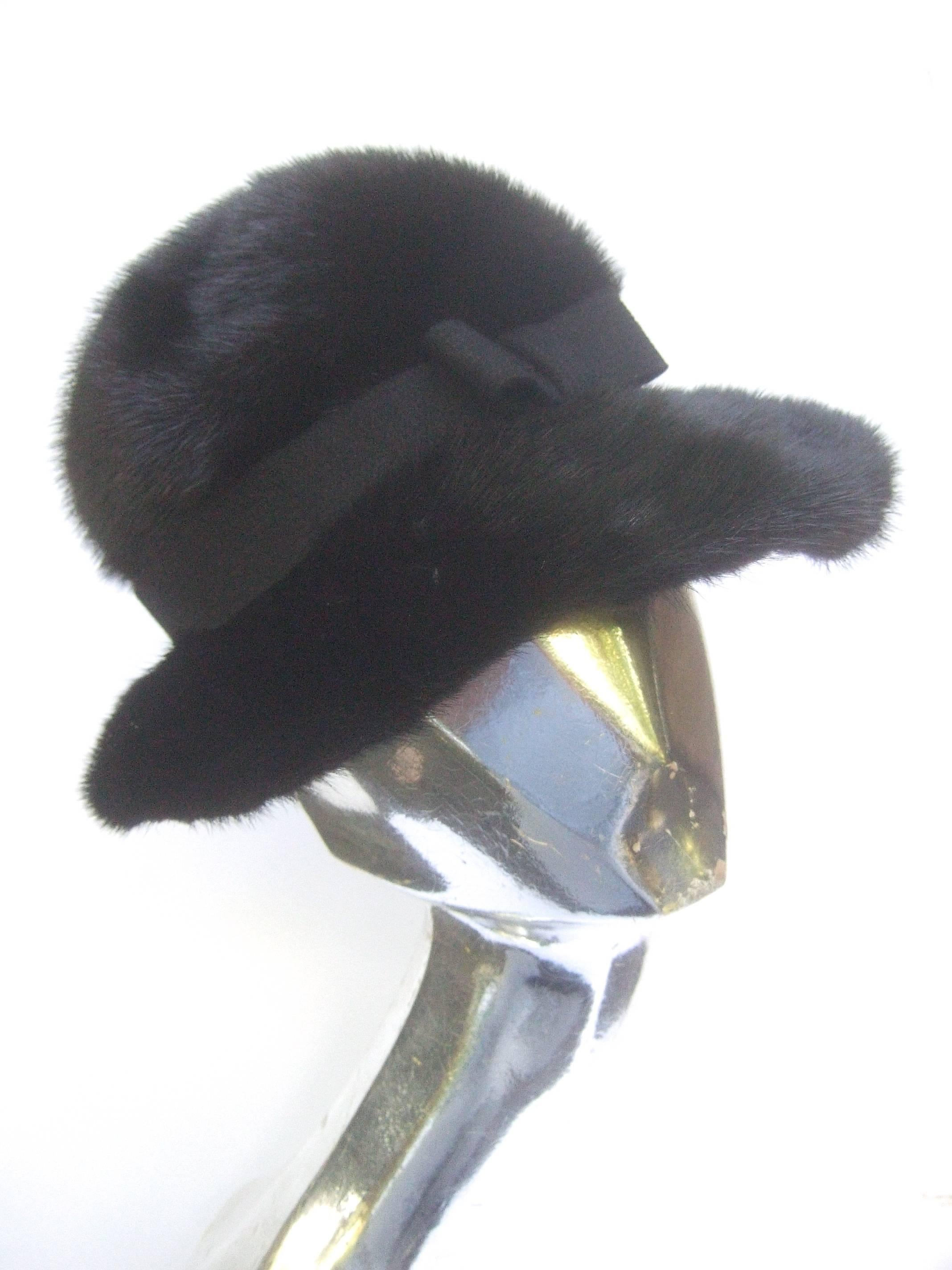 Saks Fifth Avenue Plush mink fedora style hat c 1970
The stylish retro hat is designed with lustrous dark 
brown ranch mink fur

The mahogany dark brown mink fur hat is embellished
with a subtle black ribbon that circles around the head
tied into