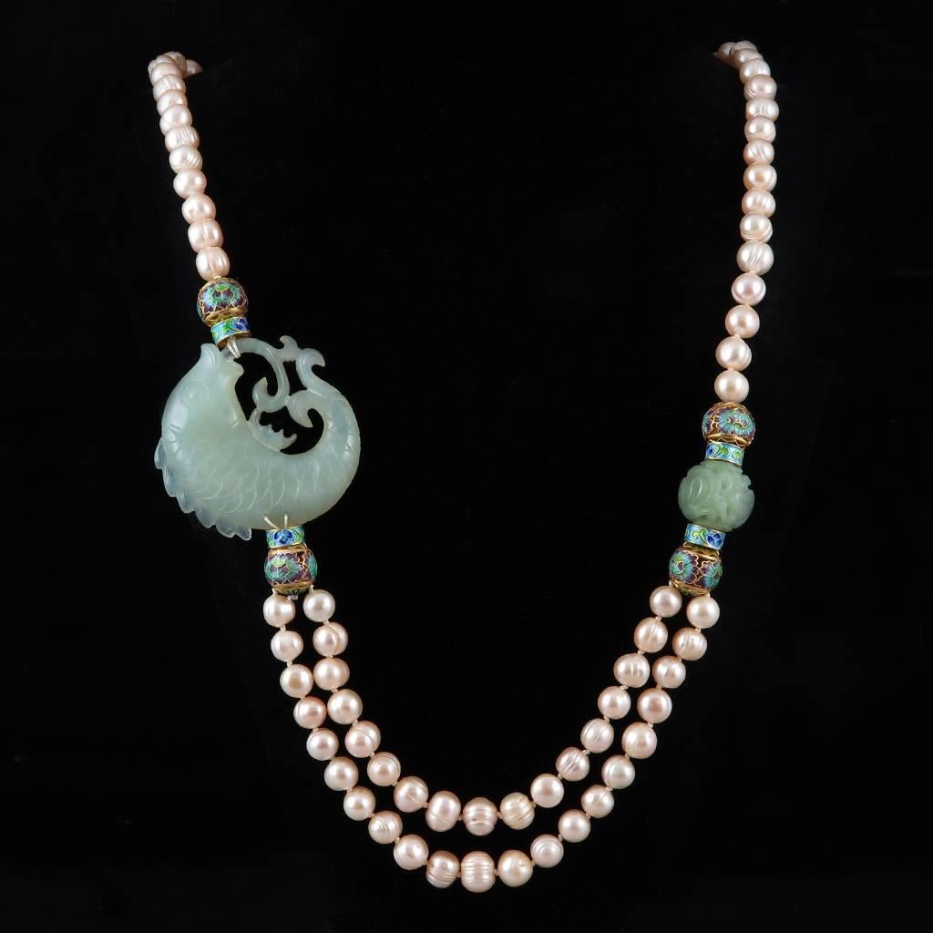 Questo pezzo è semplicemente bellissimo. Il pesce Koi è finemente intagliato in serpentino verde celadon ed è abbinato a un drago di serpentino intagliato sull'altro lato. Entrambi gli intagli di serpentino sono incorniciati da perline smaltate a
