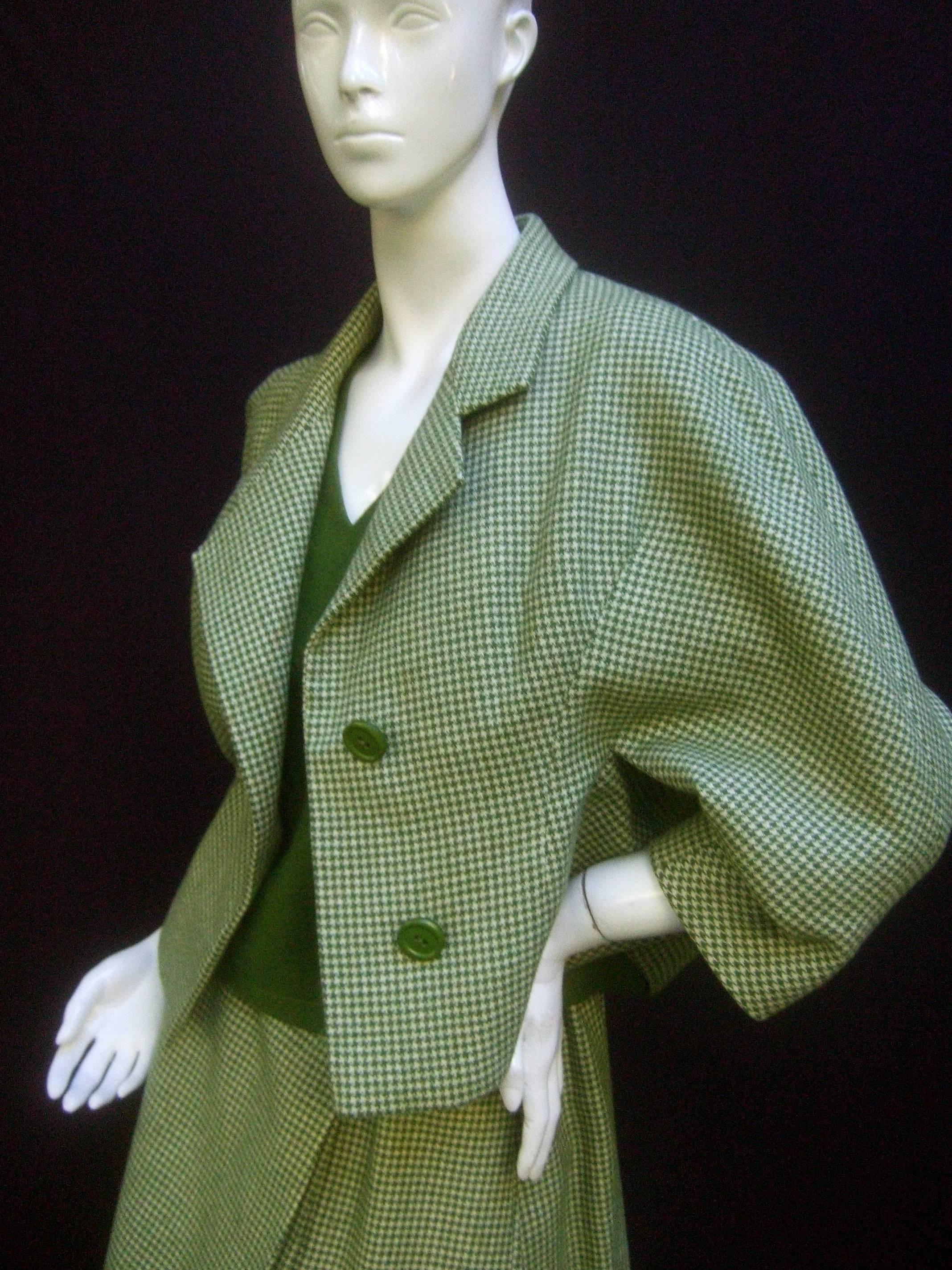 Galanos 1970s green wool houndstooth skirt suit ensemble 
The stylish retro skirt suit is designed with a matching 
green and white houndstooth checkered jacket and skirt 
 
The jacket silhouette has voluminous raglan sleeves 
The sleeveless shell