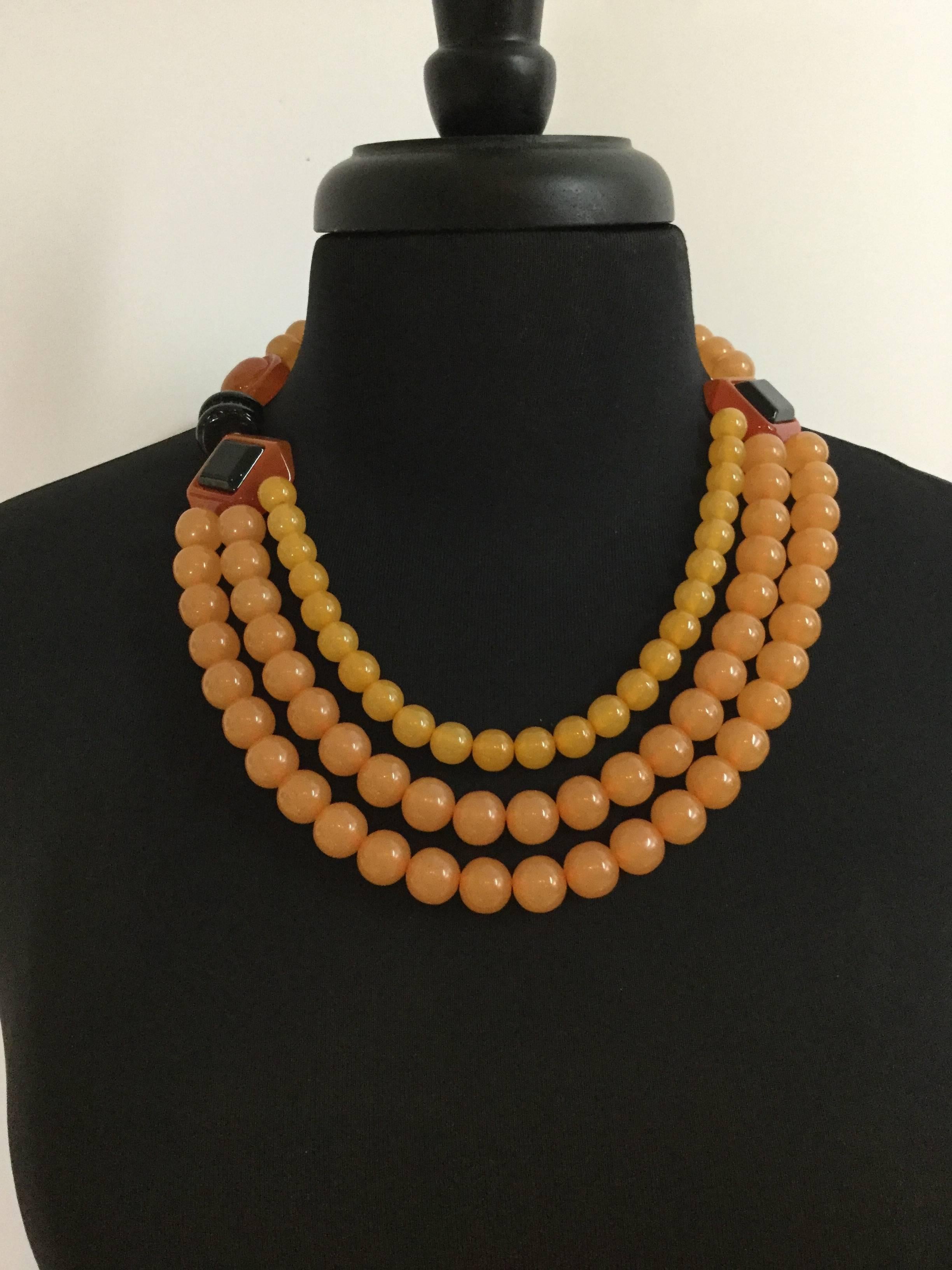 Super bold and graphic Ugo Correani Lucite beaded necklace of chunky graduated amber colored beads accented with large Deco style elements fashioned to resemble 1930's bakelite. The lucite feels warm and smooth to touch. The design is just superb!