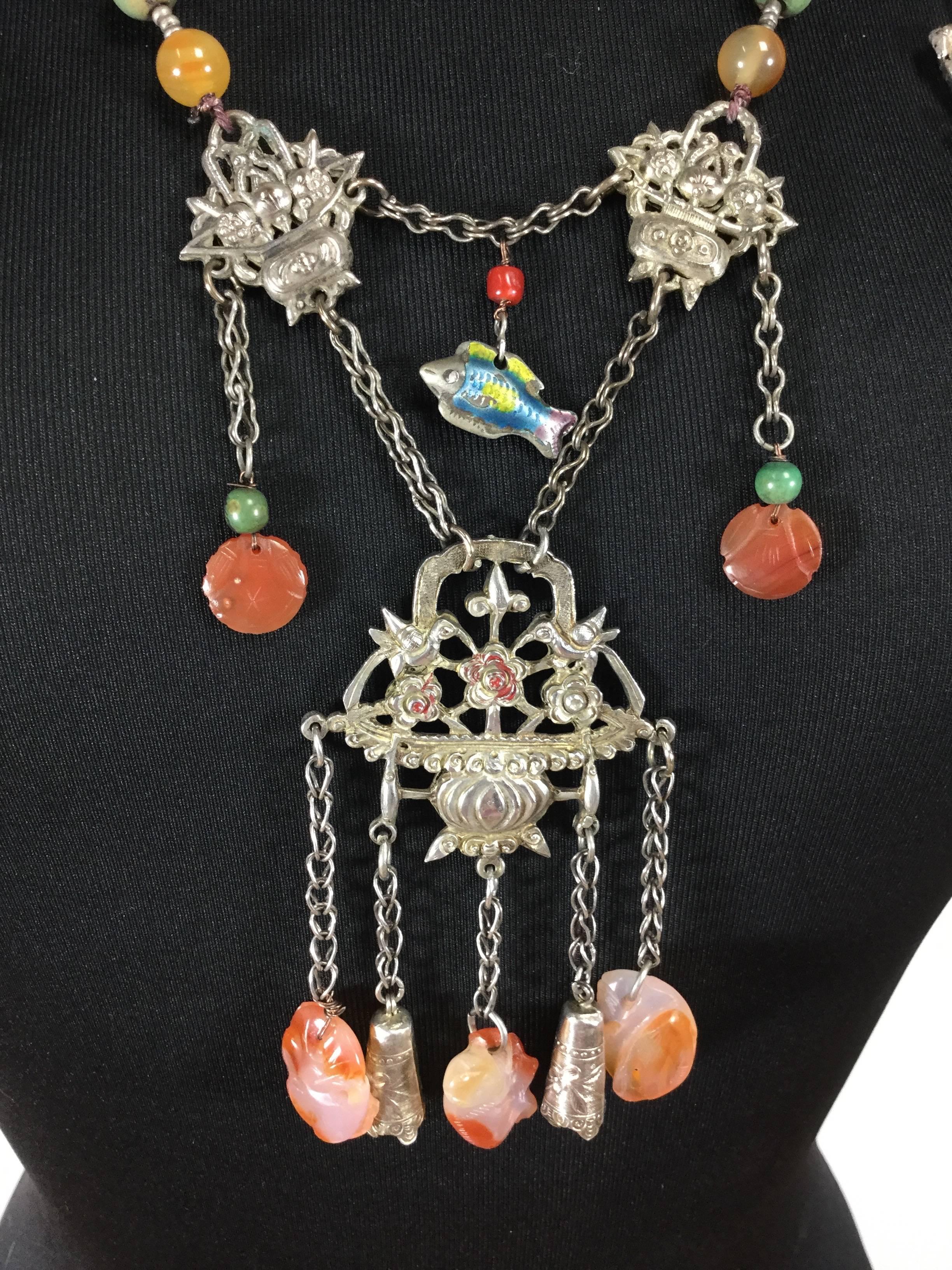 This majestic antique Mandarin court necklace features a rich collection of charms from the Chinese Qing Dynasty which dated from 1644 to 1912.  There is a finely detailed foo dog which is a mythical creature who guards the temple. There is an