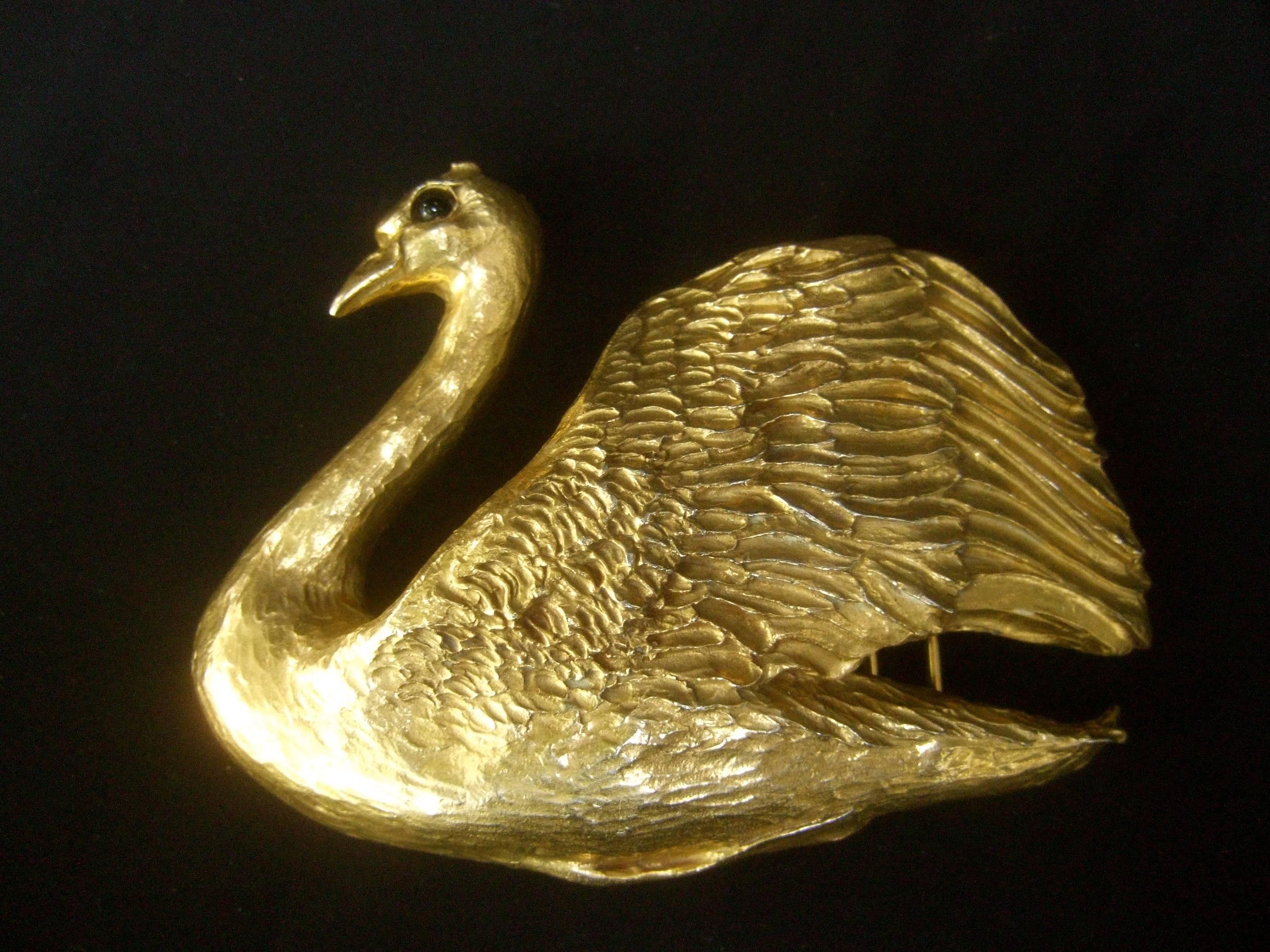 Christopher Ross Massive gilt metal swan belt buckle c 1983
The incredible belt buckle is designed with a huge
scale gilt metal swan. The luminous gilt metal plating
is 24k gold over base metal

The swan is embellished with a black glass cabochon