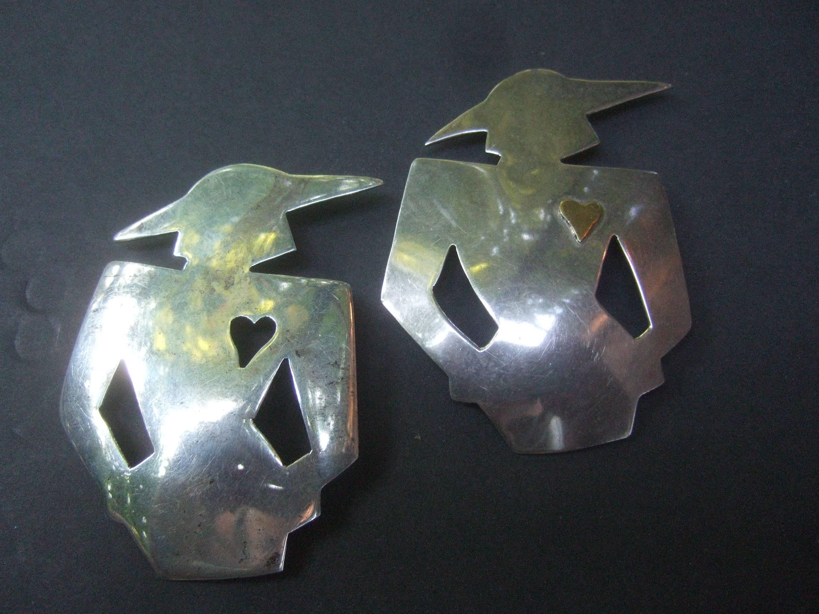Paire unique de broches figuratives en argent sterling pour femmes, datant des années 1980
La paire de broches artisanales est conçue avec la silhouette 
d'un couple de femmes chic habillées de chapeaux élégants

L'une des broches a un cœur découpé