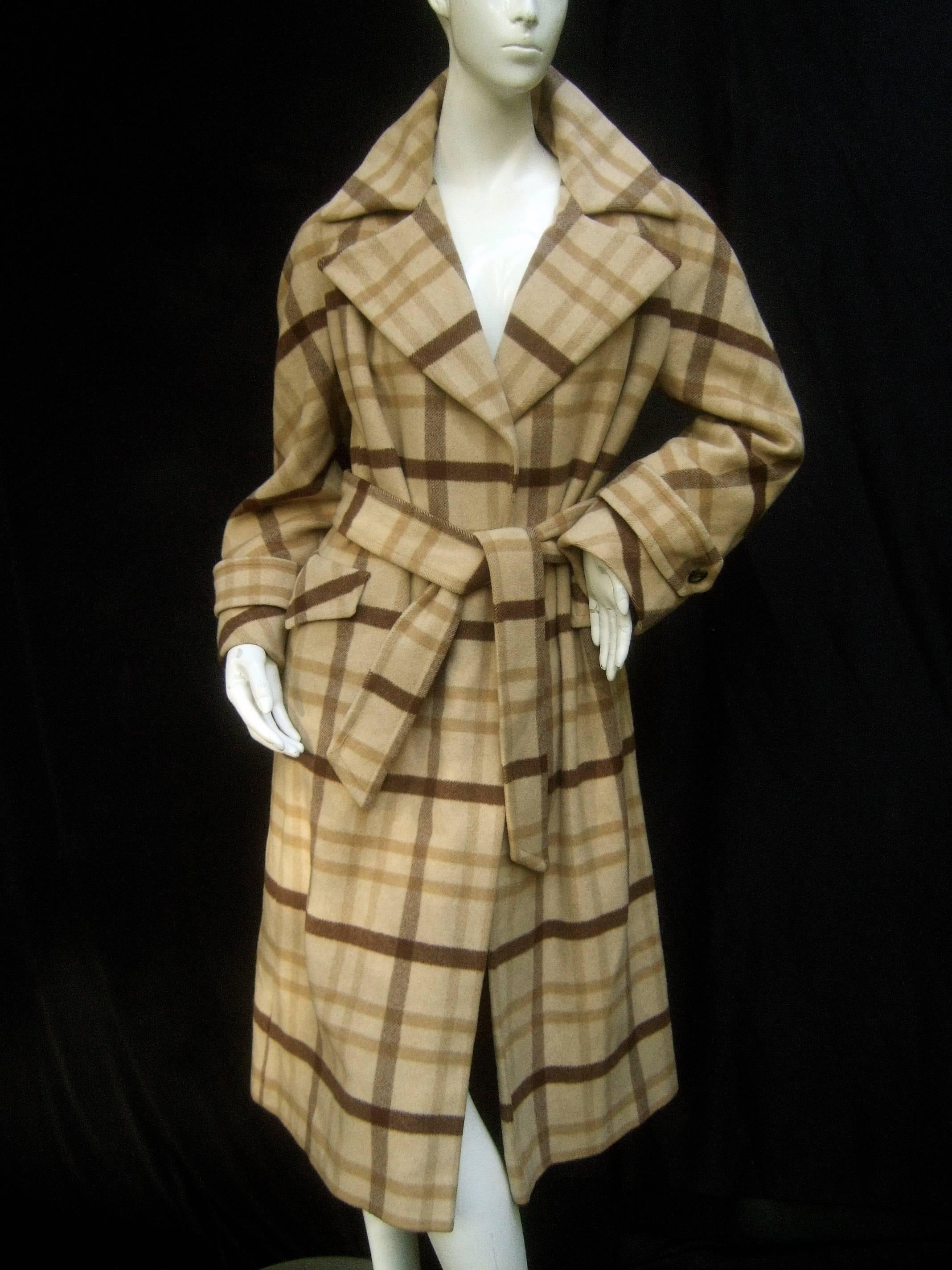 Neiman Marcus Cashmere plaid belted trench coat c 1970
The stylish belted trench coat is designed with luxurious 
cashmere with beige and brown plaid stripes throughout 

The wide pointed collar can be folded around the neck
Designed with a pair of