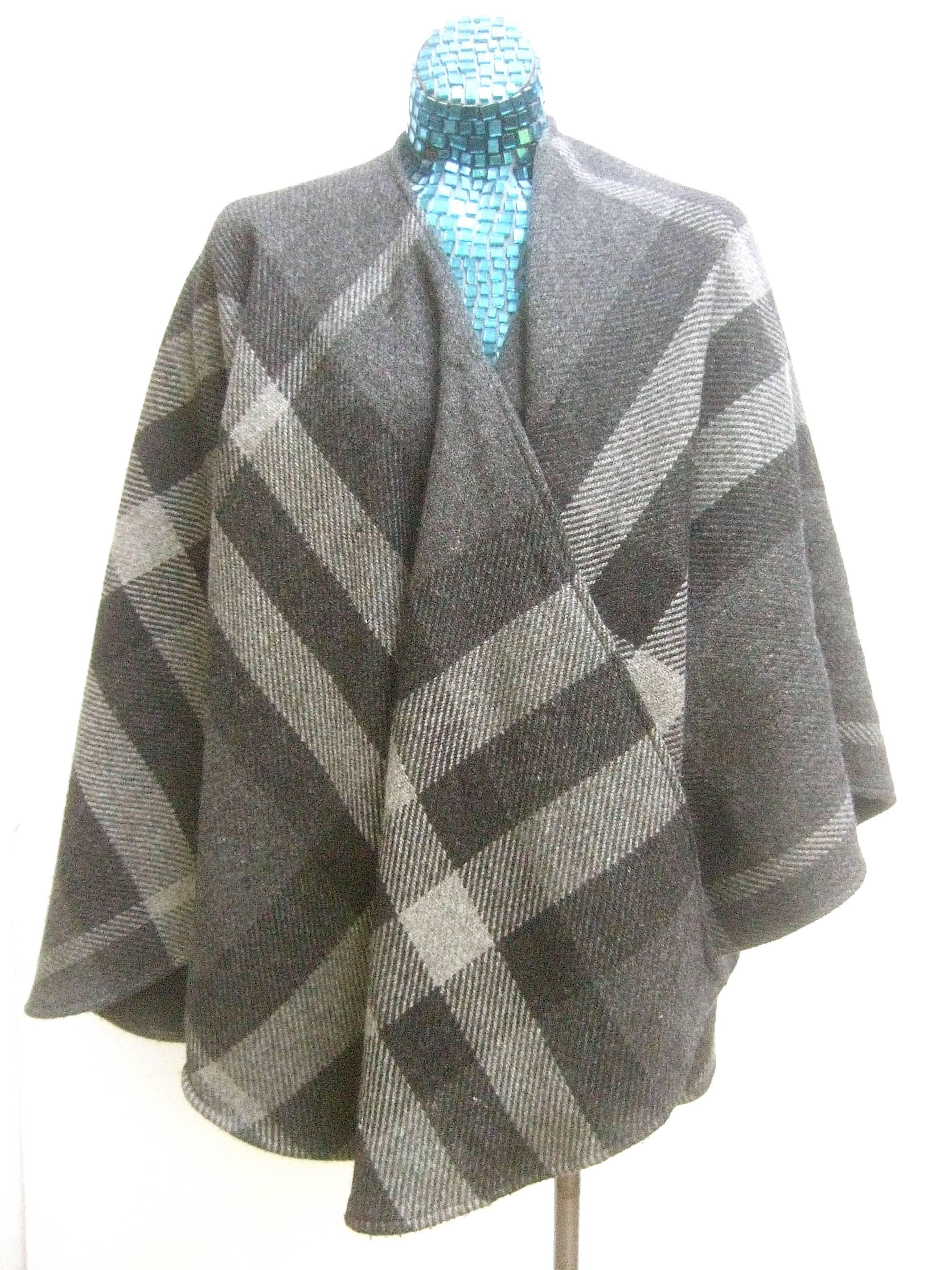 Burberry Stylish gray plaid wool shawl wrap 
The classic burberry shawl /cape is designed 
with various shades of gray hues 

The muted shades of gray plaid have
a quiet understated elegance 

Labeled: Burberry 

The loose silhouette crosses over