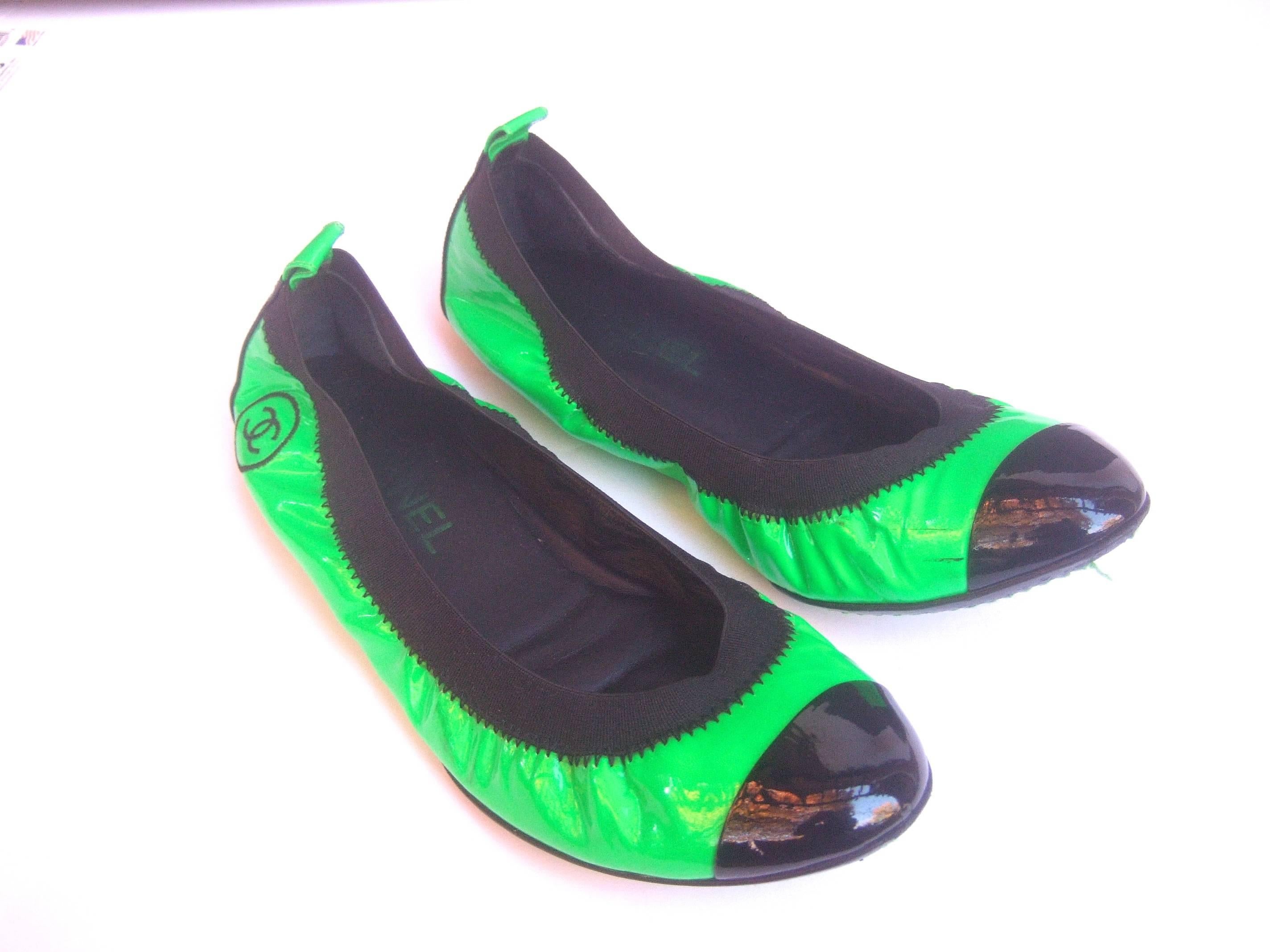 Chanel Italian patent leather skimmer flats Size 37
The stylish Chanel flats are designed with bright
green patent leather 

The toes and back exterior heels are accented 
with shiny black patent leather. The sides of each
shoe are adorned with