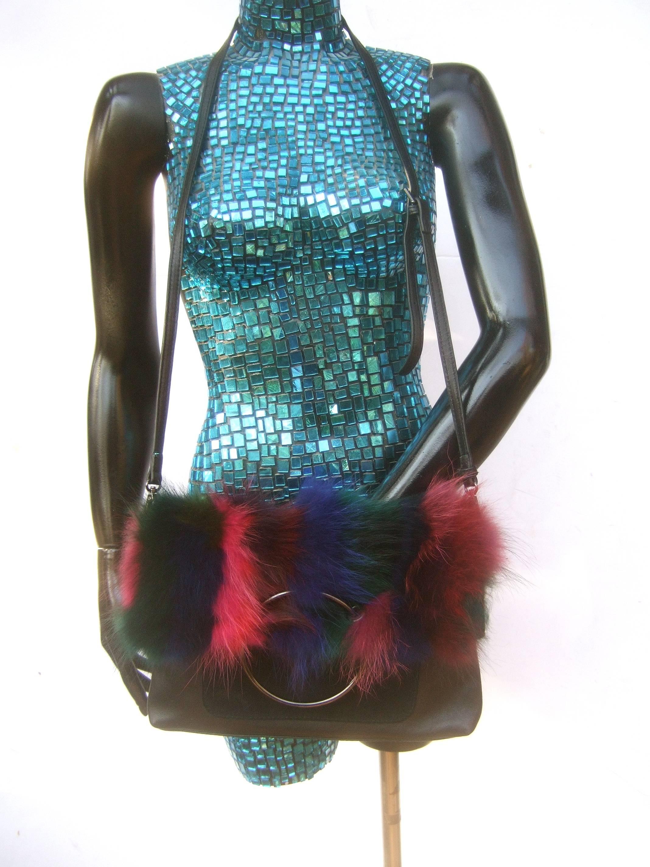 Dyed fox fur black leather and suede handbag designed by Sondra Roberts. The unique handbag is designed with a spectrum of dyed 
fox fur that runs across the flap cover that range from fuchsia, violet,
burgundy, sapphire blue, and hunter green 